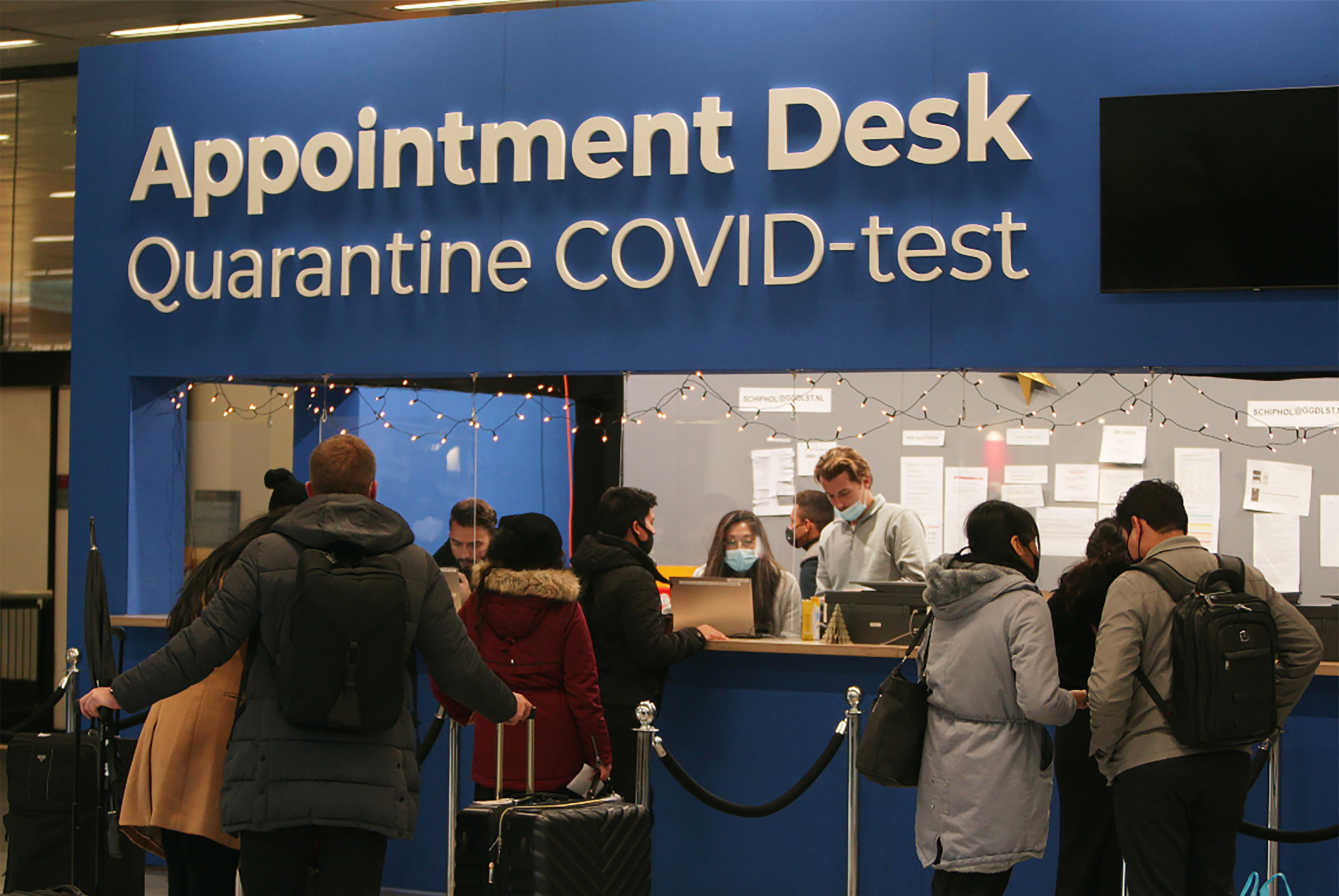 Des voyageurs sont vus à un bureau de rendez-vous pour des tests de quarantaine et de coronavirus à l'aéroport de Schiphol le 28 novembre à Amsterdam, aux Pays-Bas. 