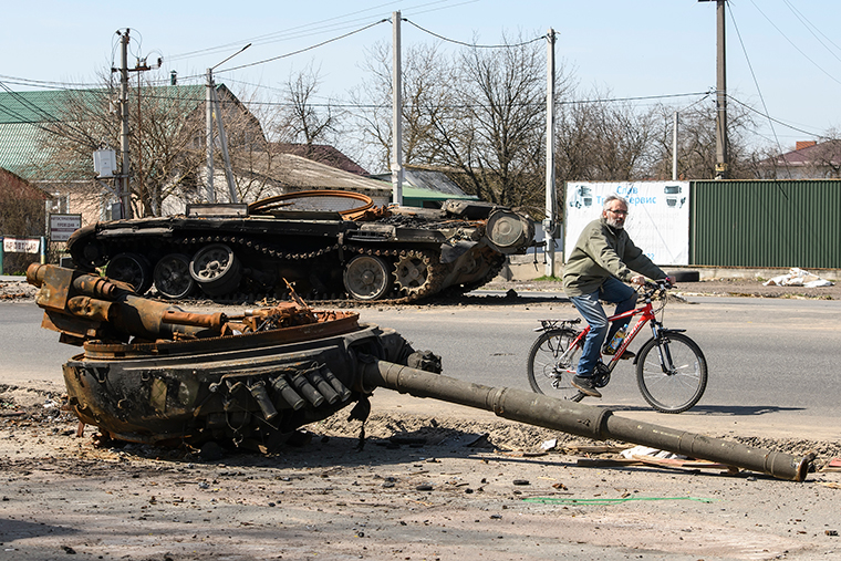 A man rides a bike near a destroyed Russian tank near Brovary, near Kyiv, Ukraine, on April 15.