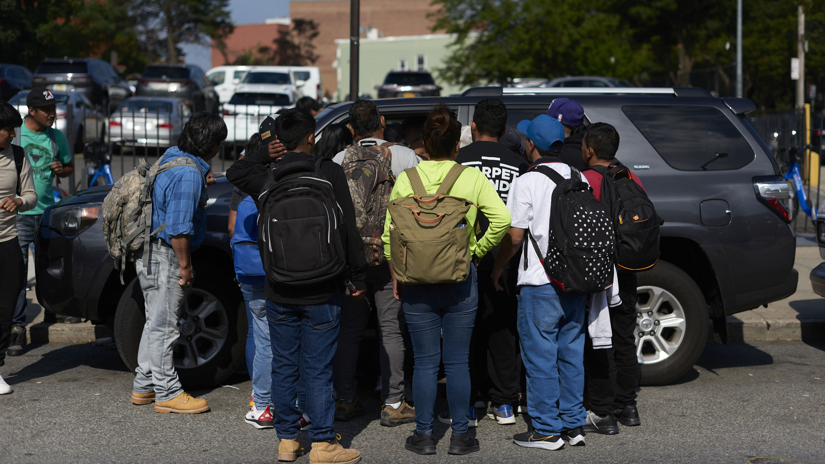 Migrant job seekers approach a vehicle looking for day laborers in the Queens borough of New York, on Thursday, June 29, 2023. 