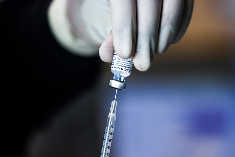 A pharmacy technician prepares a dose of the Pfizer-BioNTech vaccine at a mass COVID-19 vaccination event on January 30, 2021 in Denver, Colorado.
