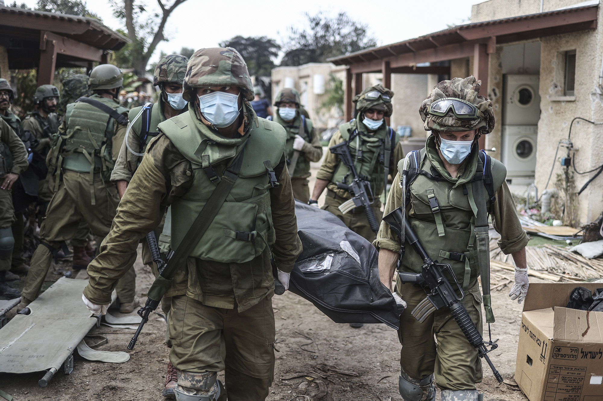Israeli forces extracting dead bodies of Israeli residents from a destroyed house in Kfar Aza, Israel, on October 10.