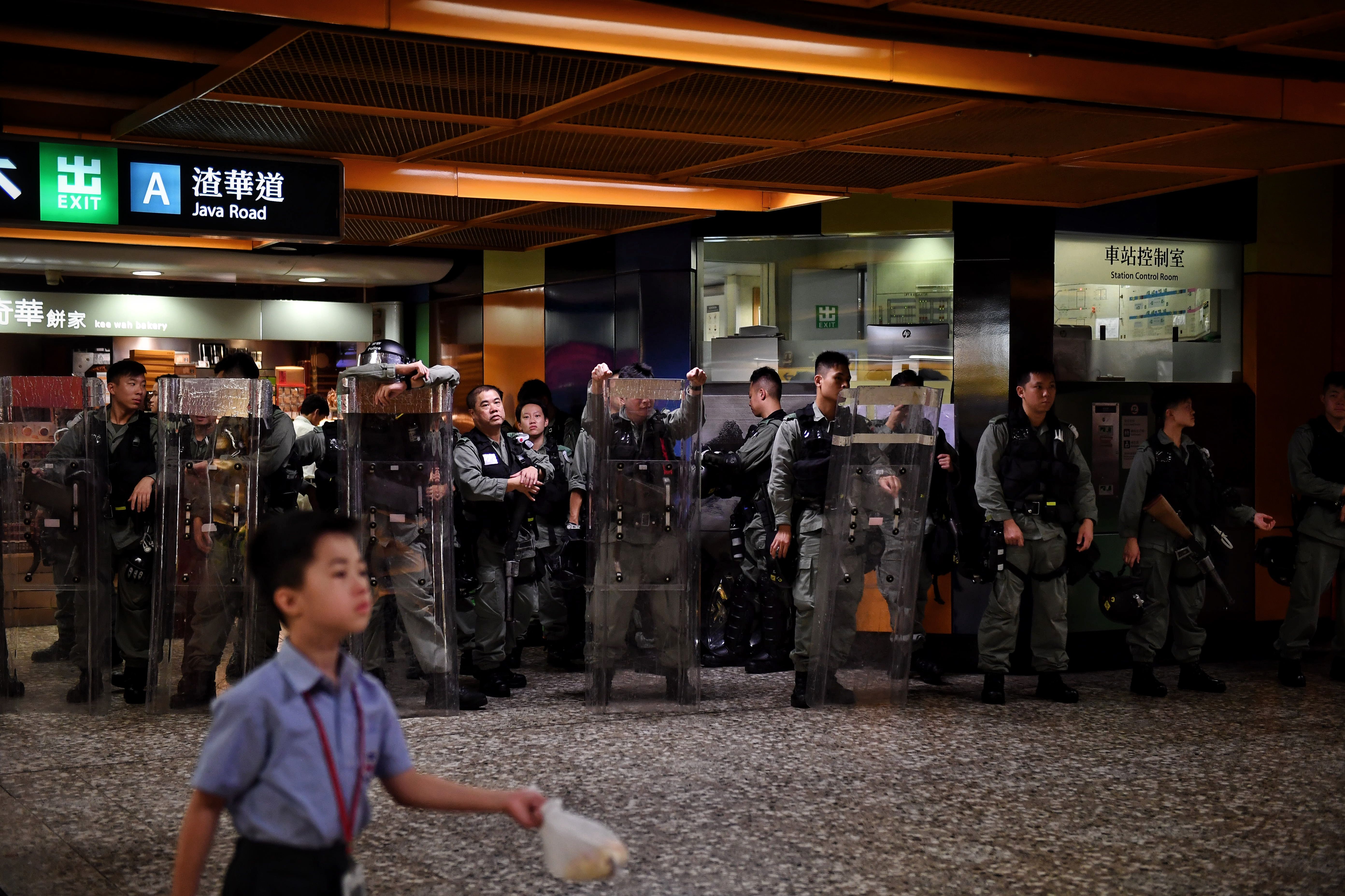 Hong Kong riot police wait inside the North Point MTR station.