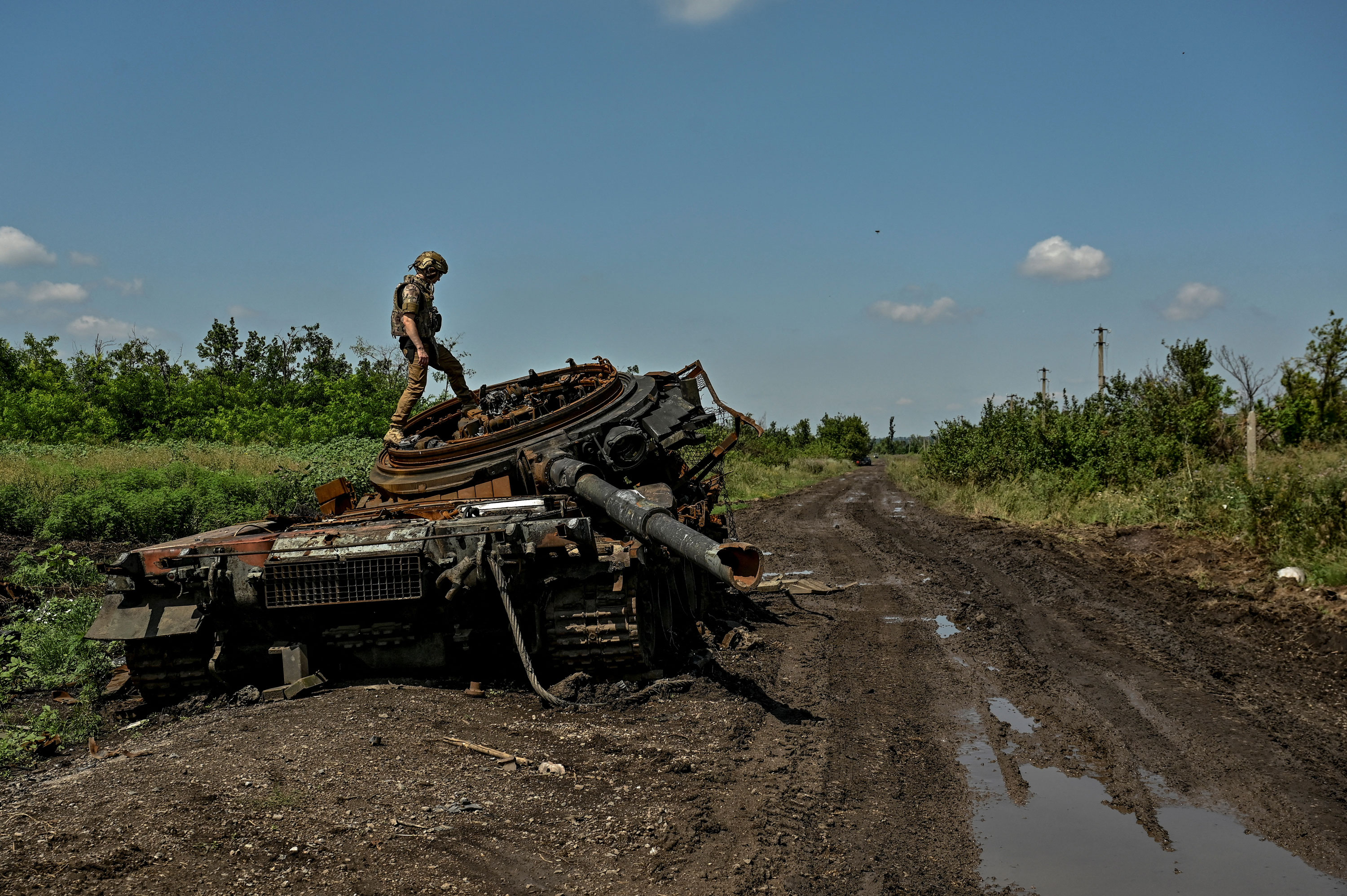 A Ukrainian serviceman inspects a destroyed Russian tank in the recently liberated village of Novodarivka in Zaporizhzhia region, Ukraine, on July 21, 2023.