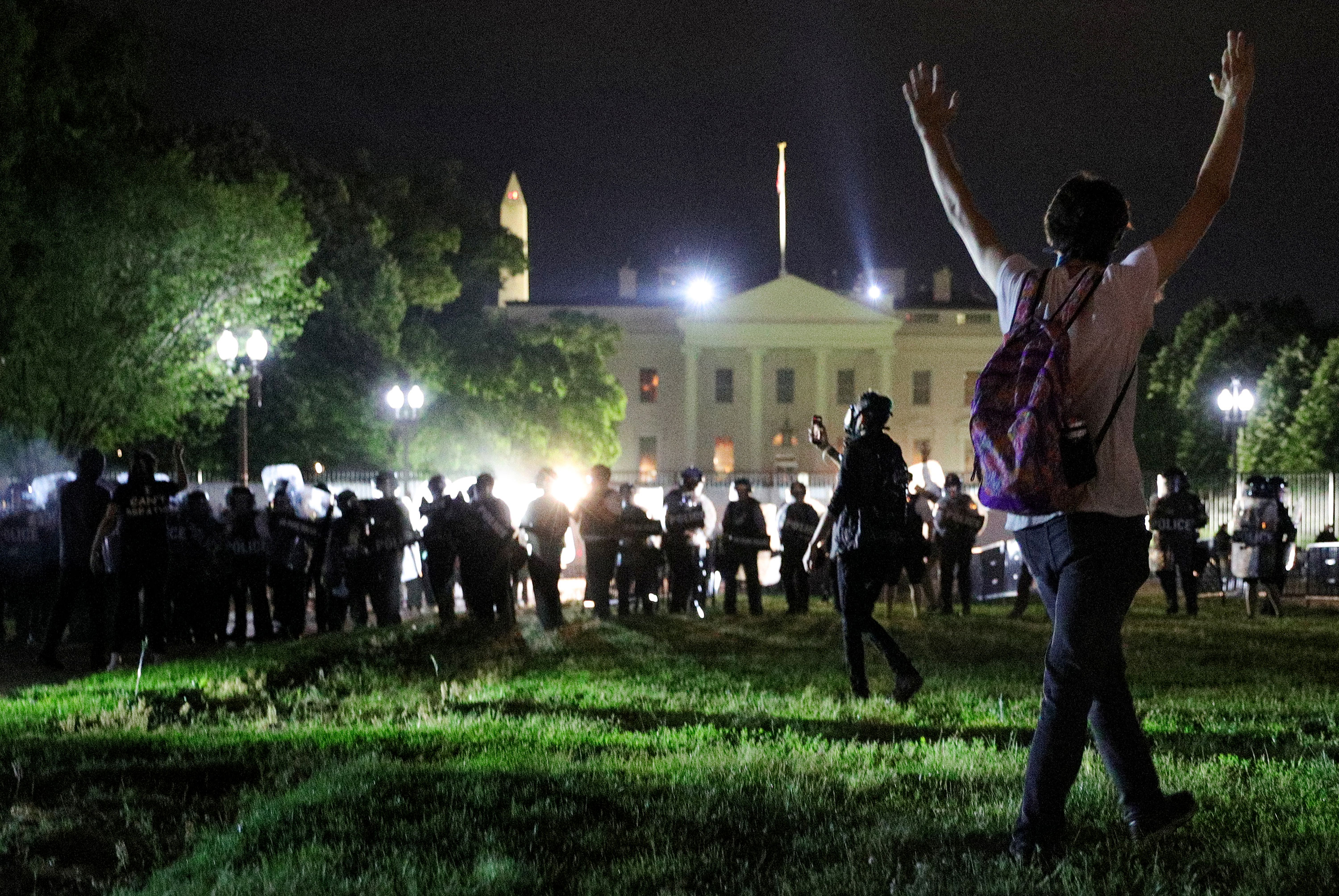 A protester holds his hands up as police officers keep demonstrators away from the White House in Washington on May 30.