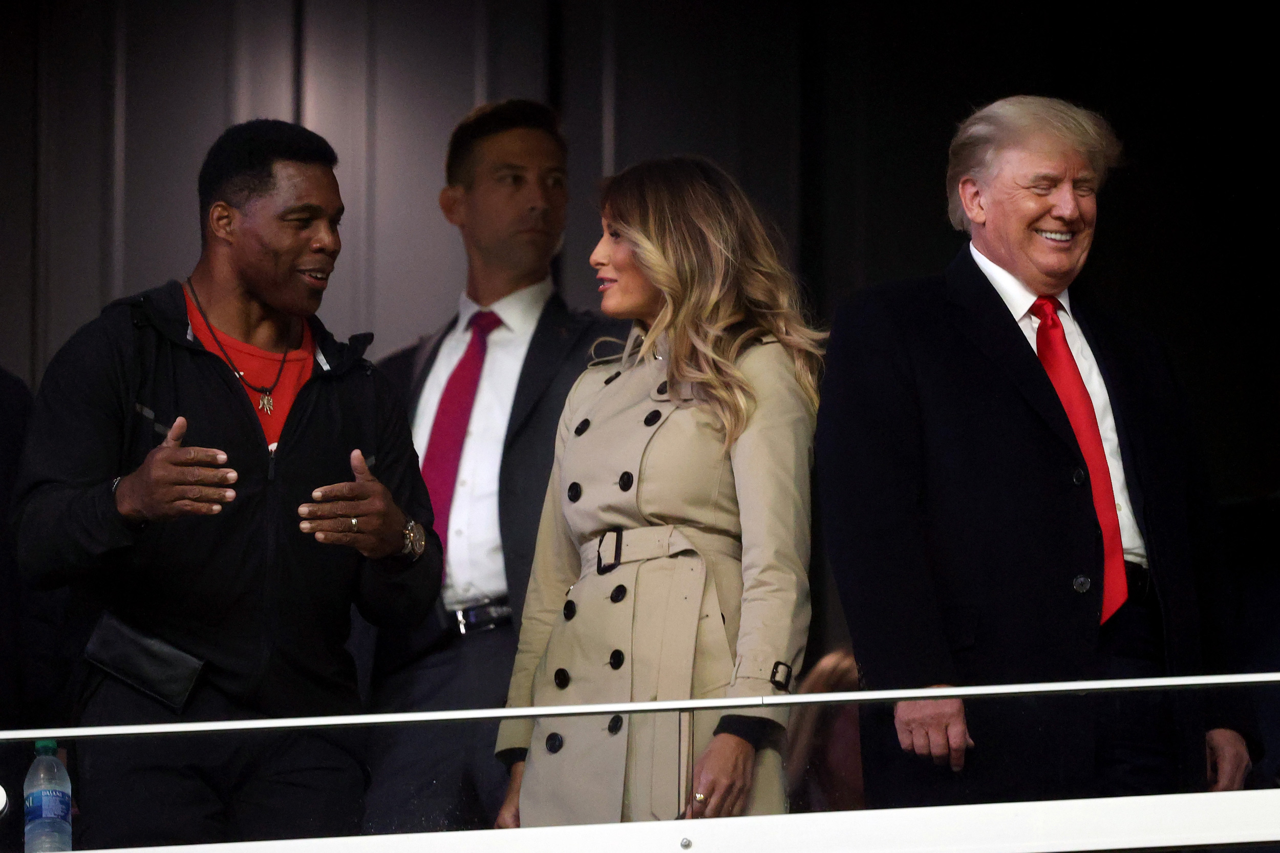 Former football player and political candidate Herschel Walker interacts with former first lady Melania Trump and former President Donald Trump prior to Game Four of the World Series on October 30 in Atlanta.