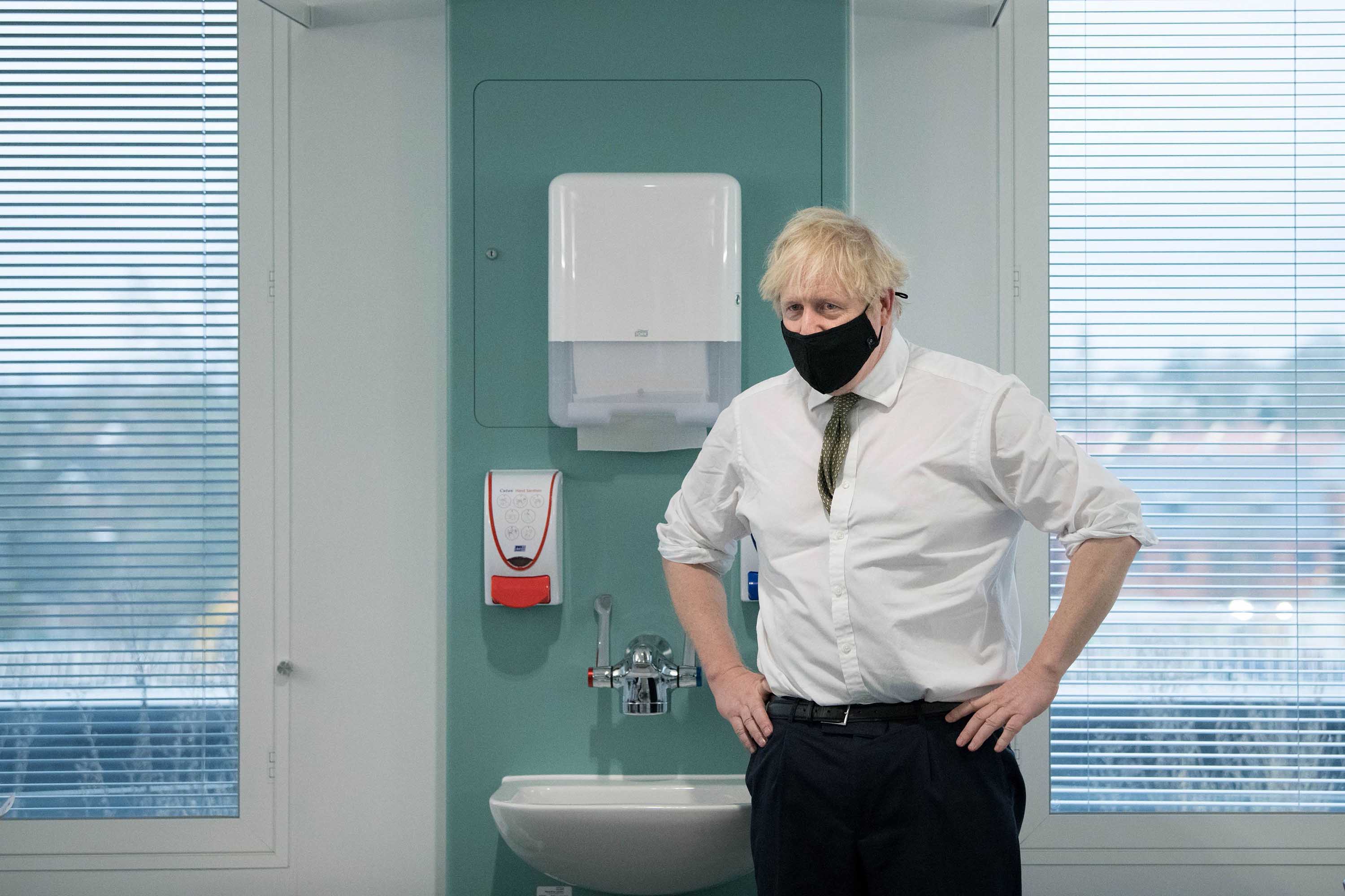 British Prime Minister Boris Johnson speaks to staff during a visit to London's Chase Farm Hospital on January 4, during the rollout of the newly approved AstraZeneca/Oxford Covid-19 vaccine.