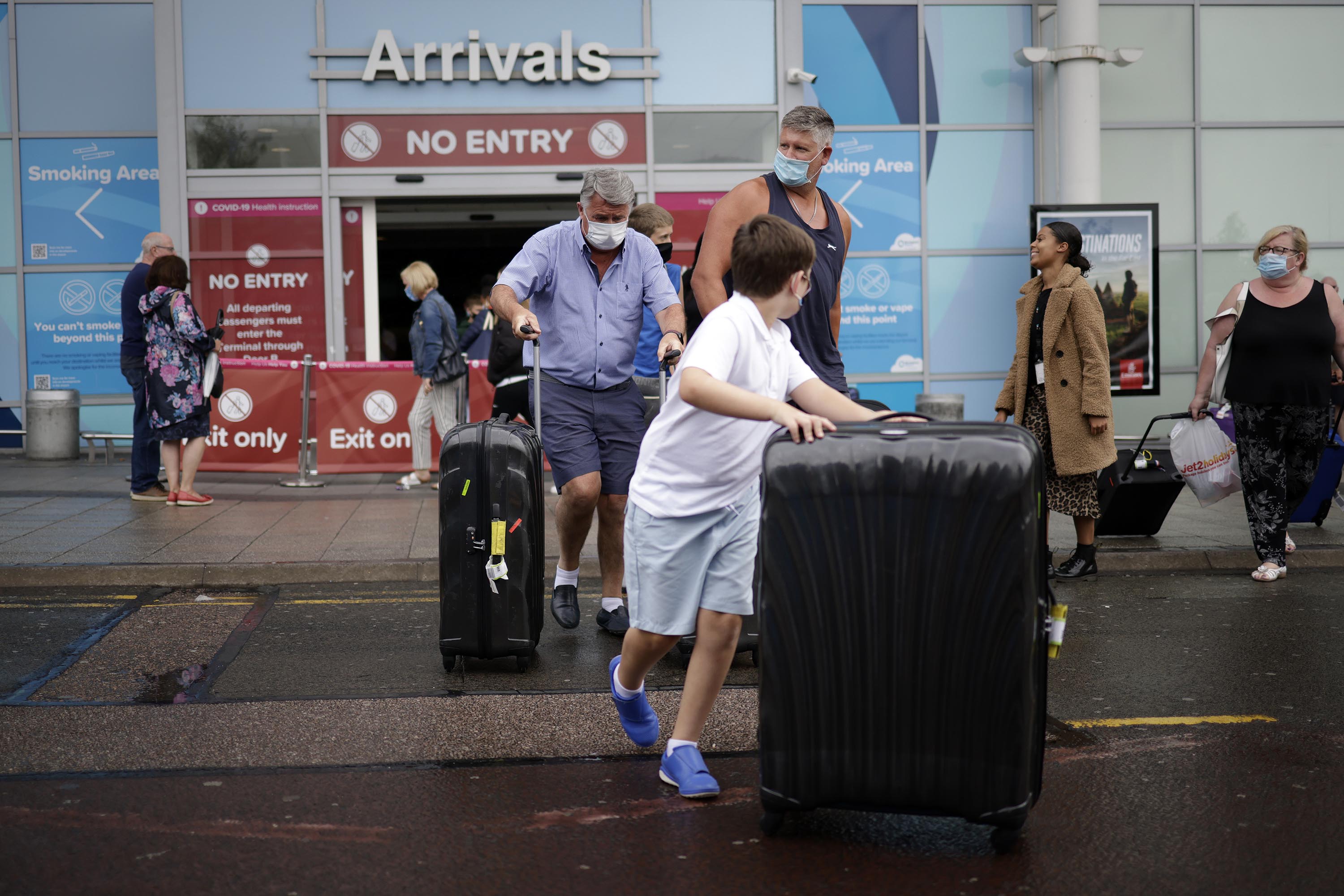 Travelers exit the arrivals terminal at Birmingham Airport on July 27, in Birmingham, England.