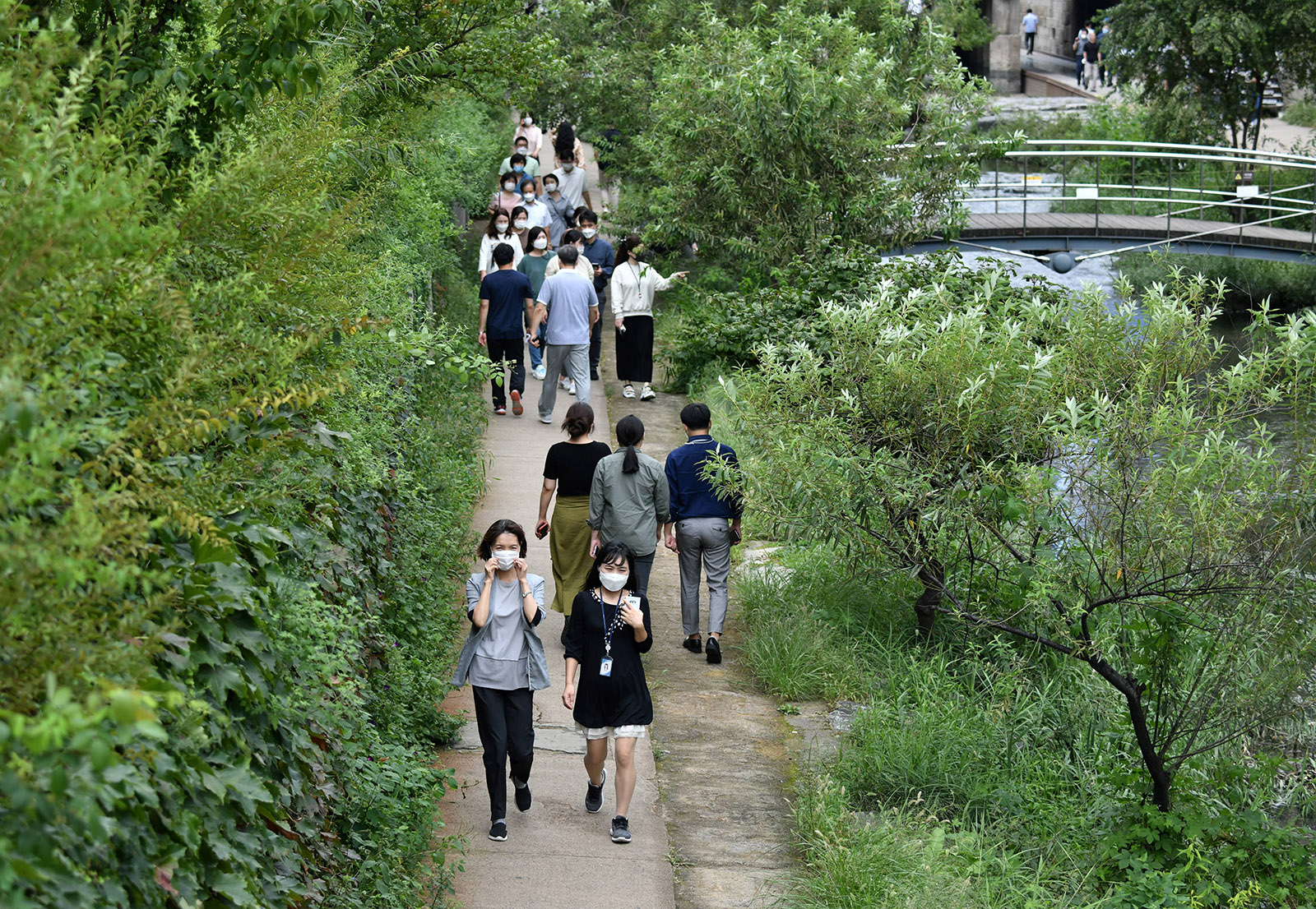 People wearing face masks walk along the Cheonggye stream in Seoul, on September 11, 2020. 