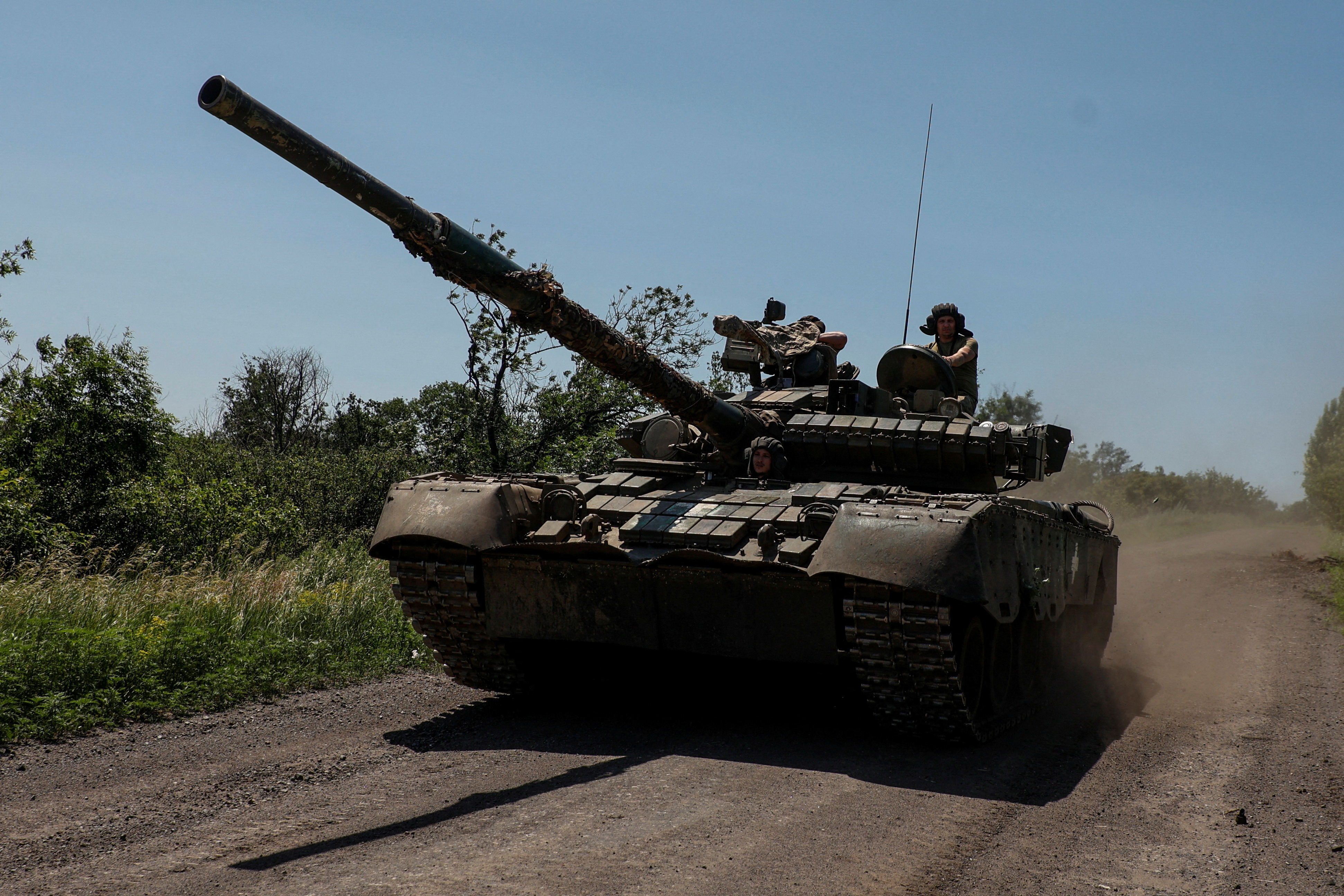 Ukrainian servicemen ride in a T-80 main battle tank captured earlier from Russian troops, along a road near the front line town of Bakhmut on June 19.