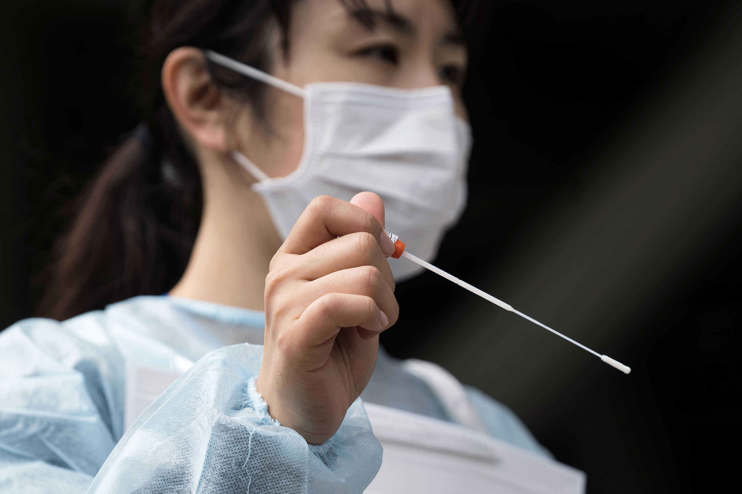A medical staff member holds a swab at a coronavirus testing site on May 10 in Kashima, Japan.