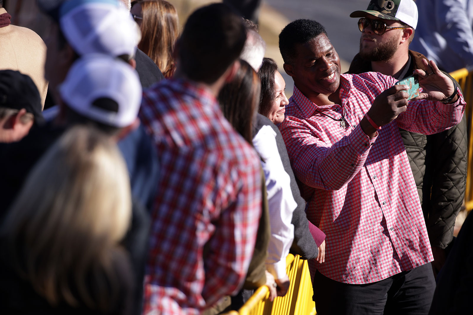 Republican Herschel Walker poses for photos with supporters during a campaign rally in Columbus, Georgia, on Thursday, December 1. 