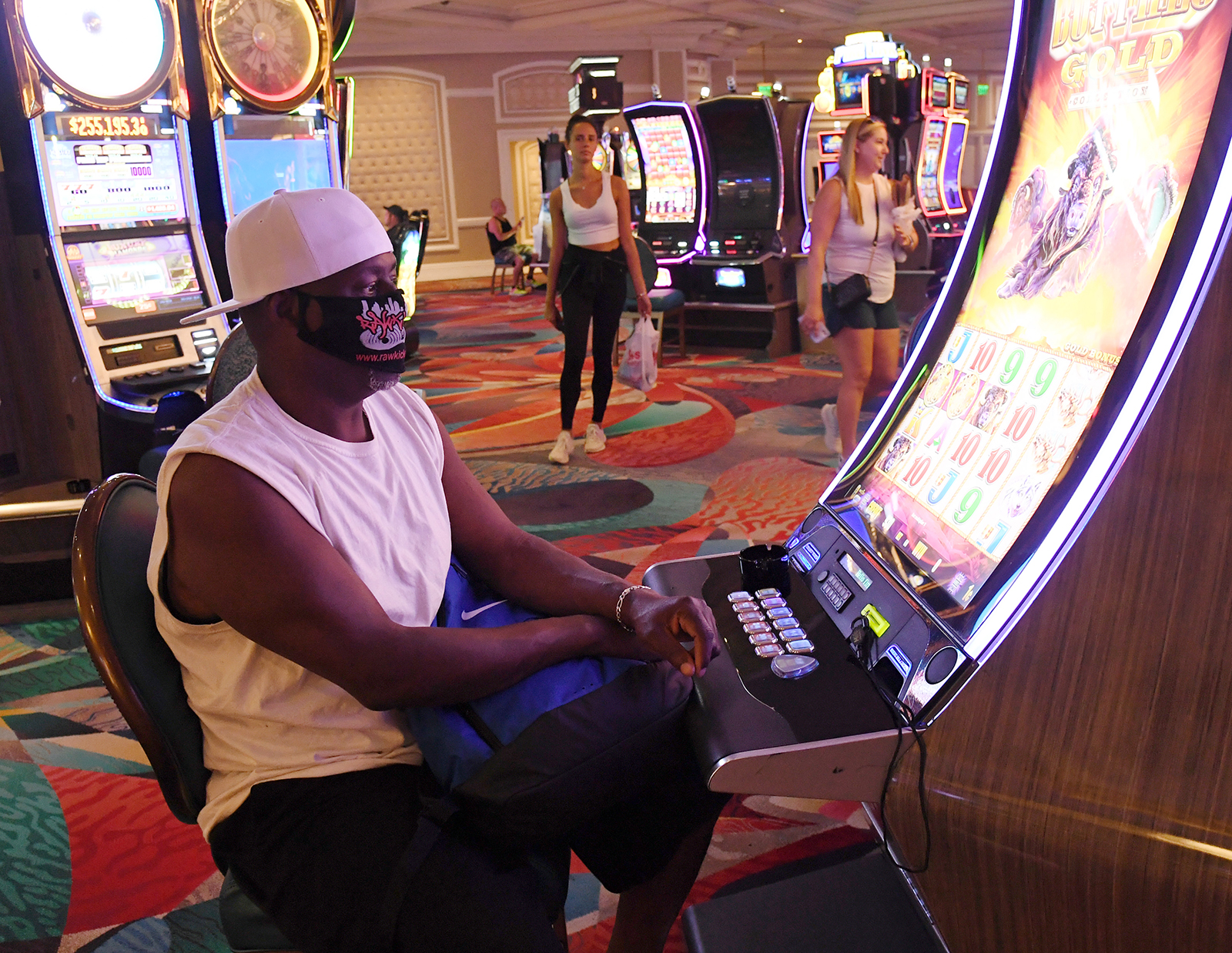 Wayne Rogers wears a mask as he plays a slot machine at Bellagio Resort & Casino on the Las Vegas Strip on June 4, in Las Vegas, Nevada.