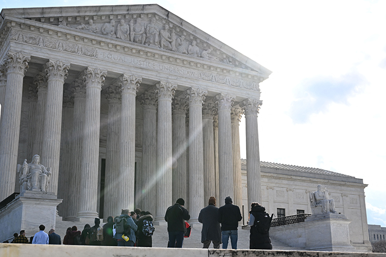 People wait in line outside the US Supreme Court in Washington, DC, today.