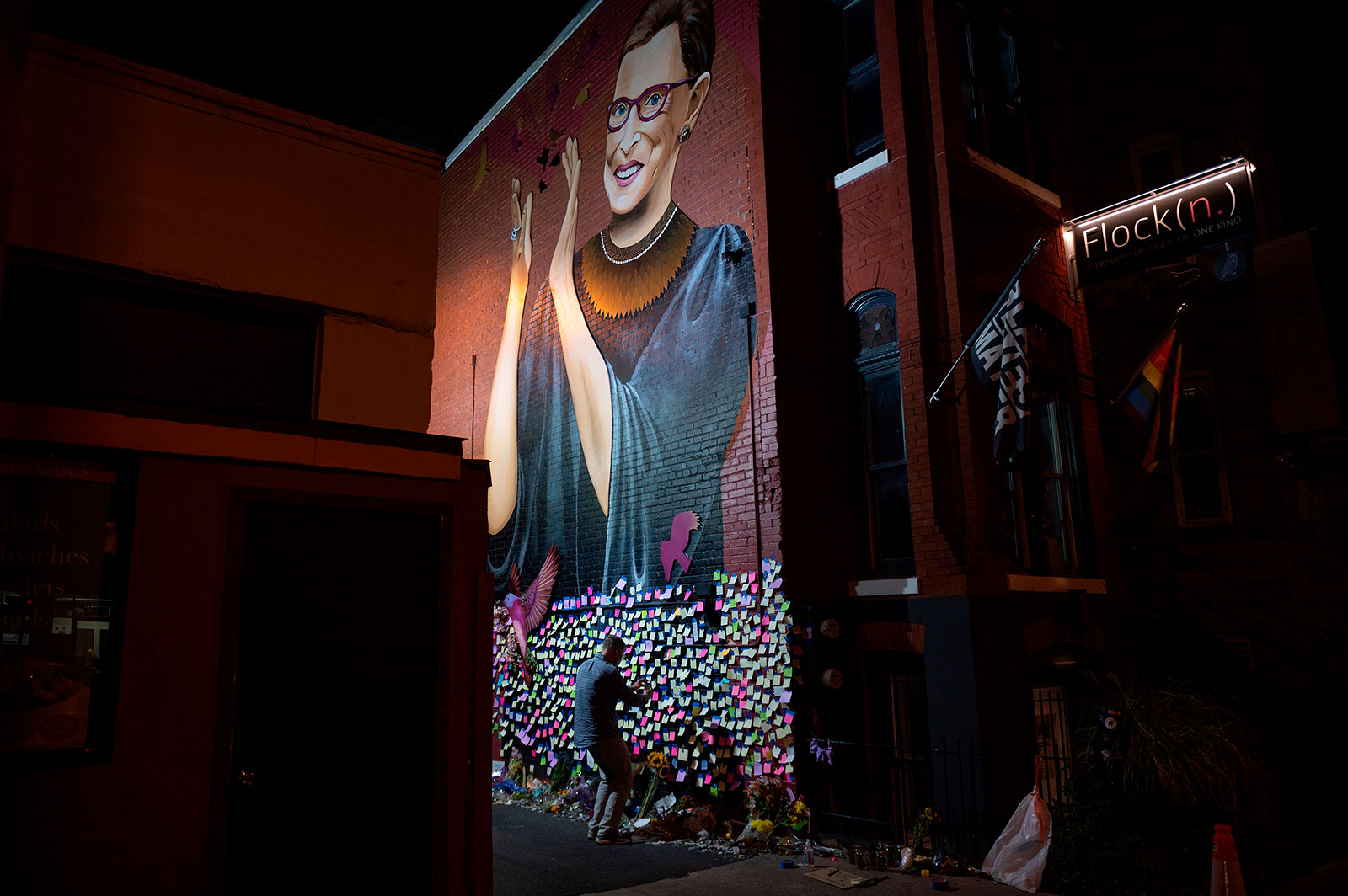 Andrew Oros takes photos of notes left at a mural for Justice Ruth Bader Ginsburg in downtown Washington, DC