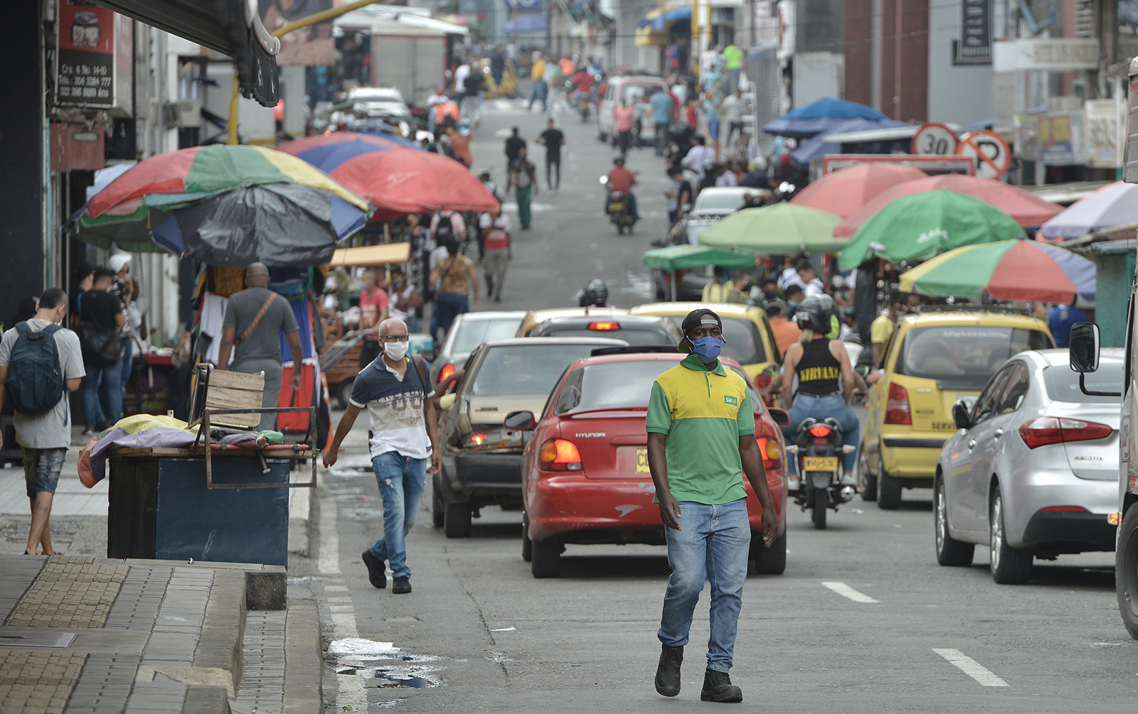A man wearing a face mask walks down a busy street in Cali, Colombia, on June 1.
