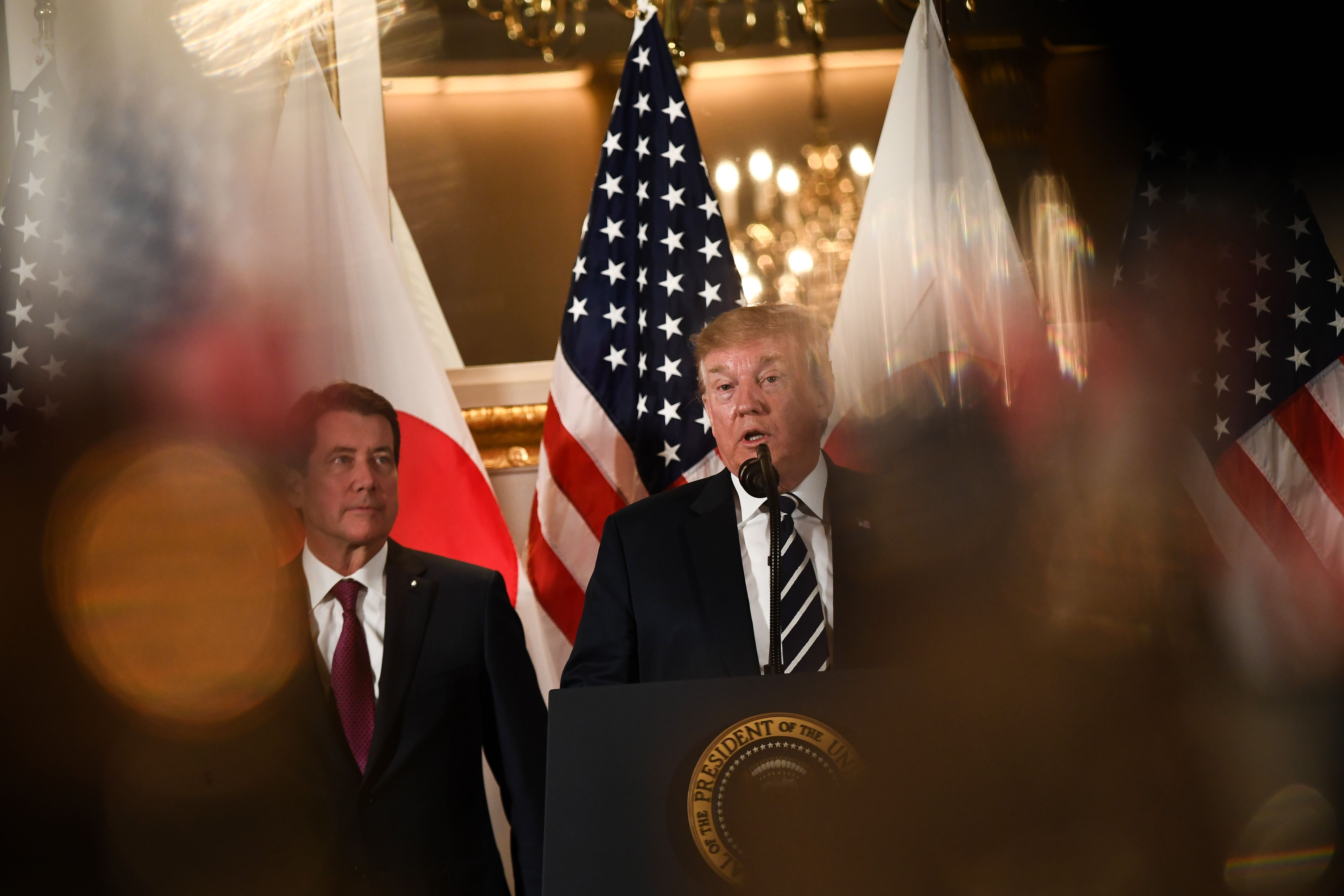 US President Donald Trump (C) speaks during a meeting with business leaders in Tokyo.