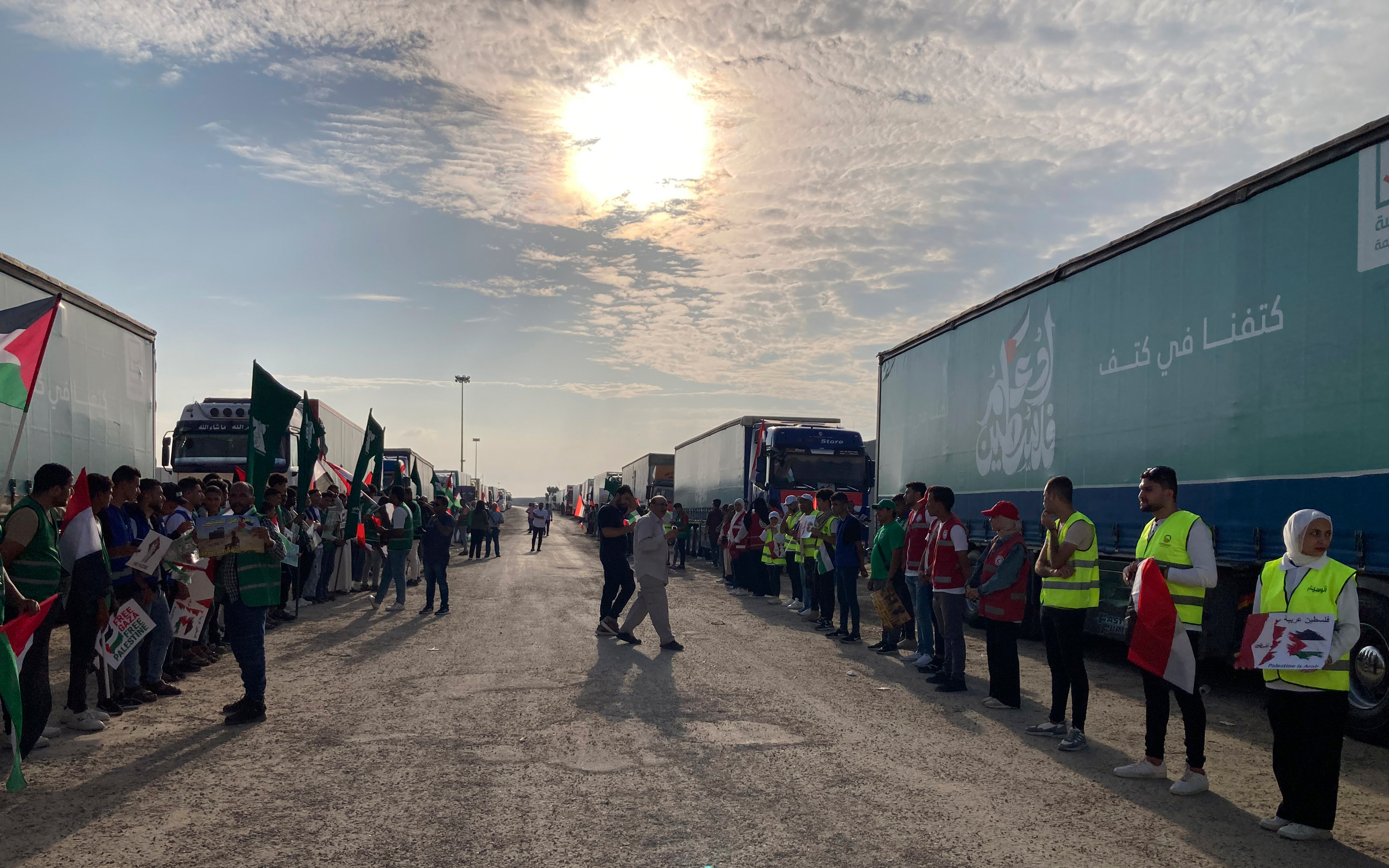 Volunteers stand in front of trucks carrying humanitarian aid at the Rafah border crossing, on October 31.