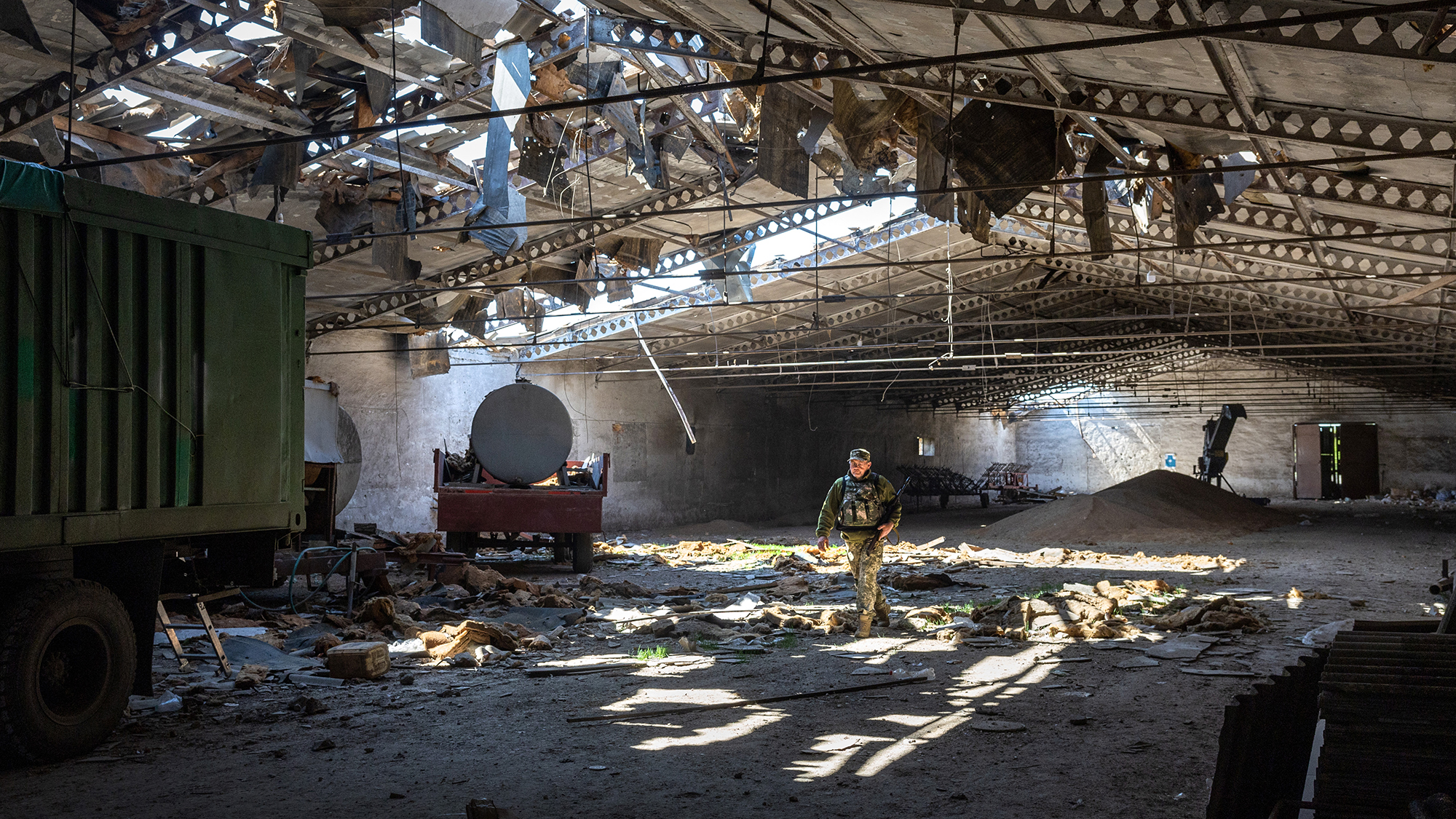 A Ukrainian army officer inspects a grain warehouse in Novovorontsovka, Ukraine, on May 6, after it was shelled by Russian forces. 