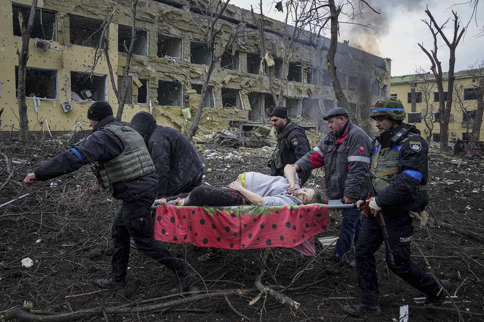 Ukrainian emergency employees and volunteers carry an injured pregnant woman from the maternity hospital in Mariupol, Ukraine, on March 9. It has now been confirmed that both mother and baby have died.