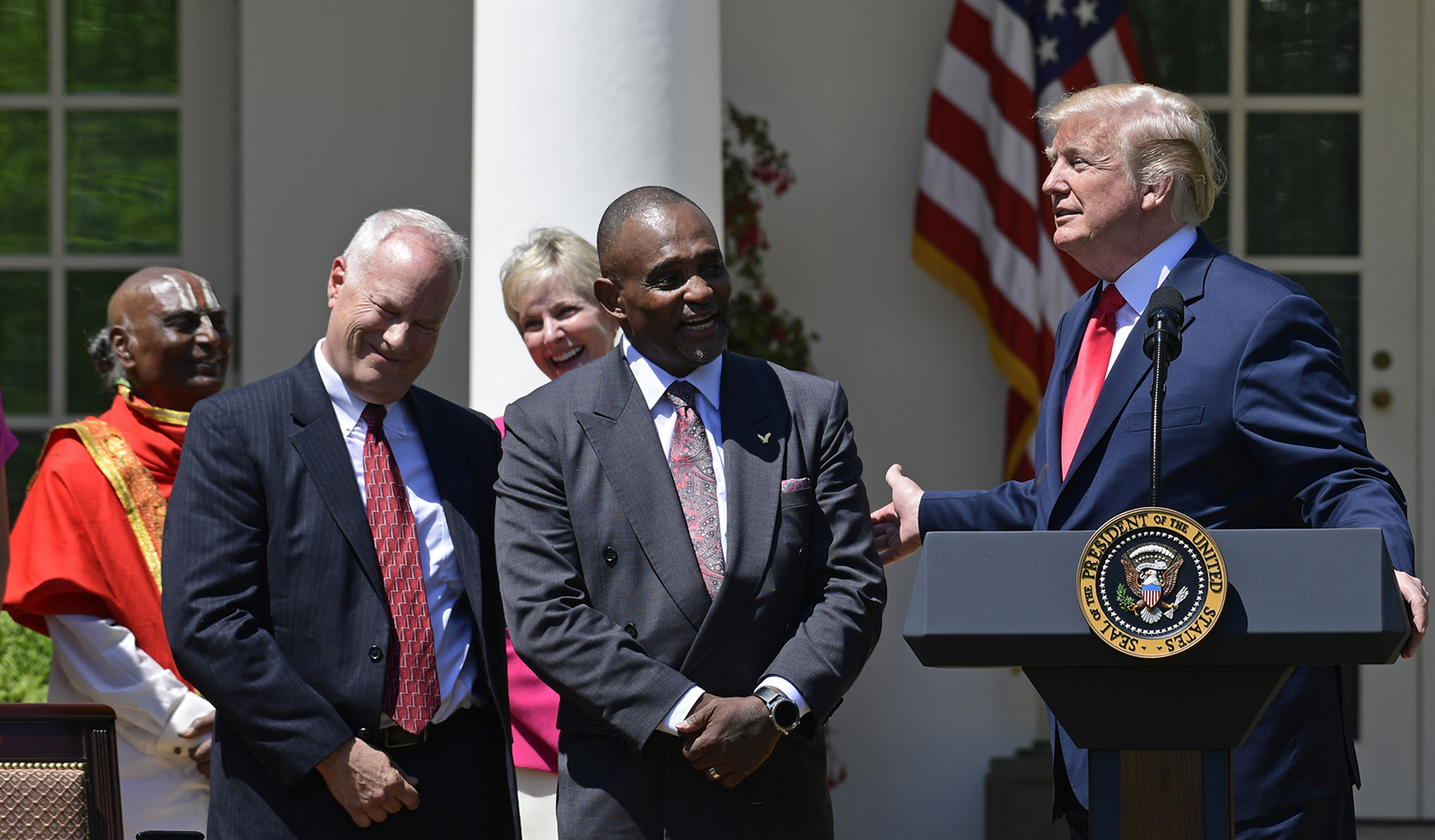 In this May 3, 2018 file photo, President Donald Trump talks about Jon Ponder, center, from Las Vegas during a National Day of Prayer event in the Rose Garden of the White House in Washington.