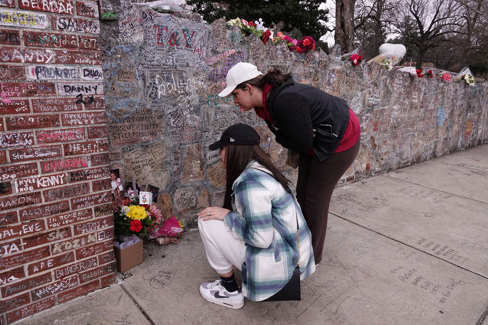Ashley Ore of Las Vegas and Hannah Mathis of Memphis pay their respect in memory of Lisa Marie Presley outside of Graceland on Friday. 
