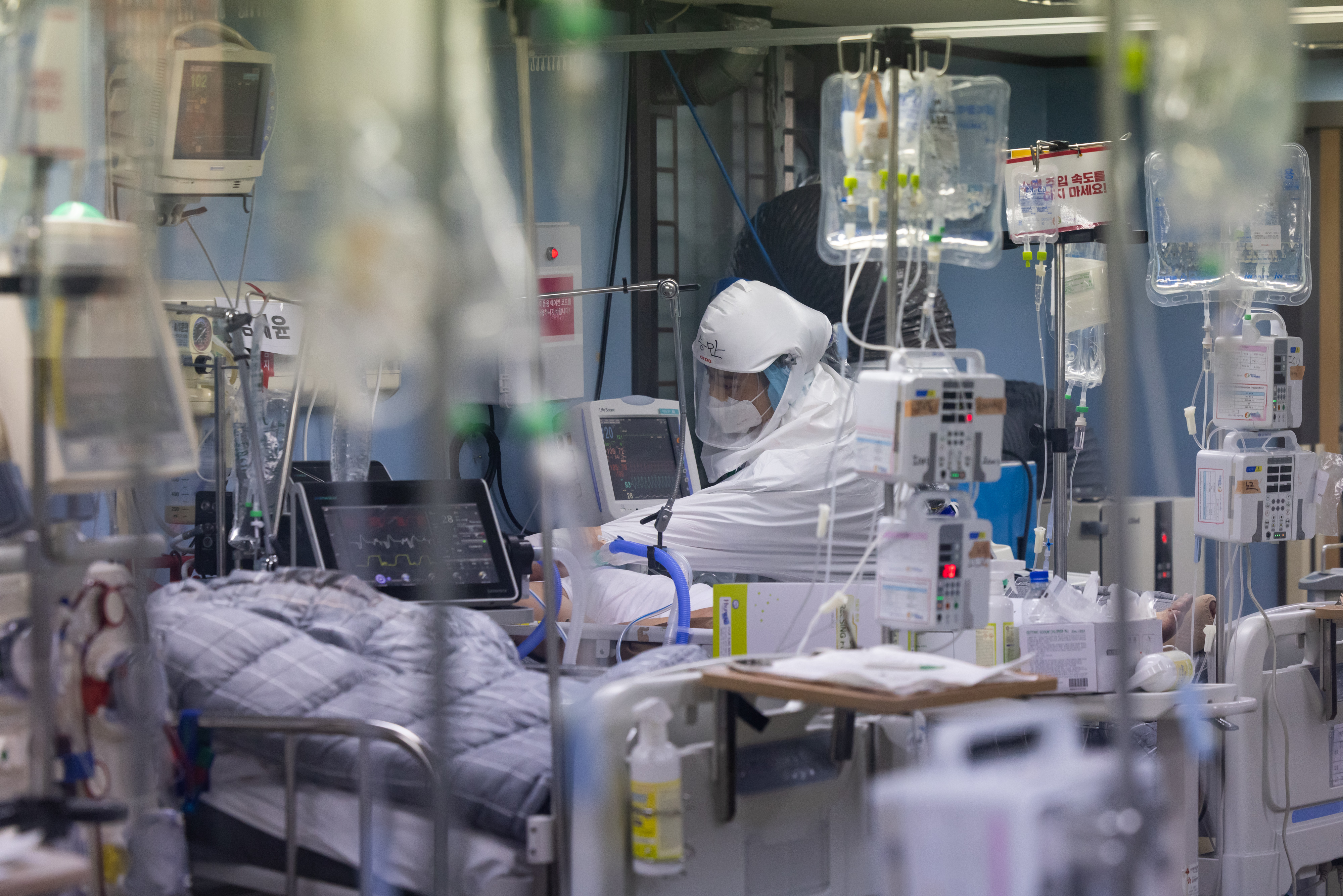A healthcare worker attends to a Covid-19 patient at an intensive care unit (ICU) at Pyeongtaek Bagae Hospital in Pyeongtaek, Gyeonggi Province, South Korea, on Thursday, Dec. 16, 2021. 