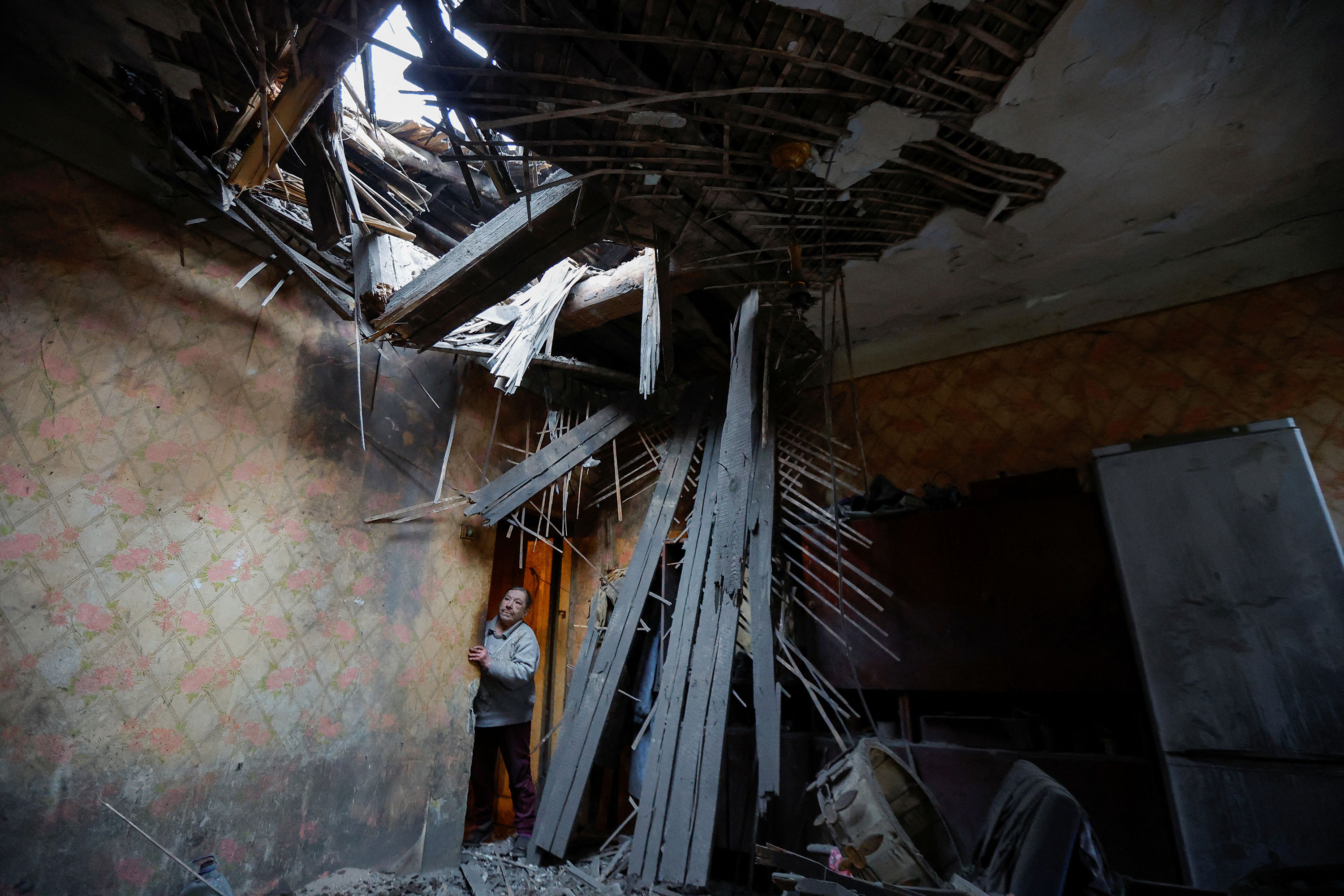 A woman looks inside a damaged house hit by recent shelling in Donetsk, Ukraine, on Tuesday.