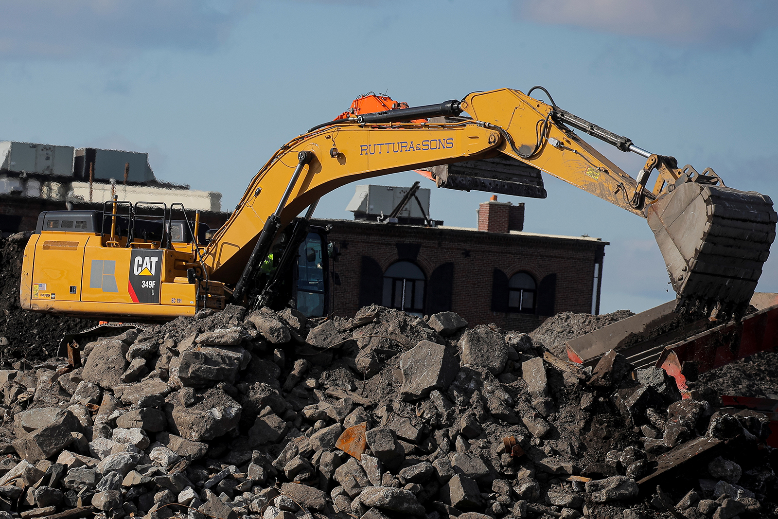 A Caterpillar excavator is seen working at a construction site near the New York Harbor in Brooklyn, in March 2021. 