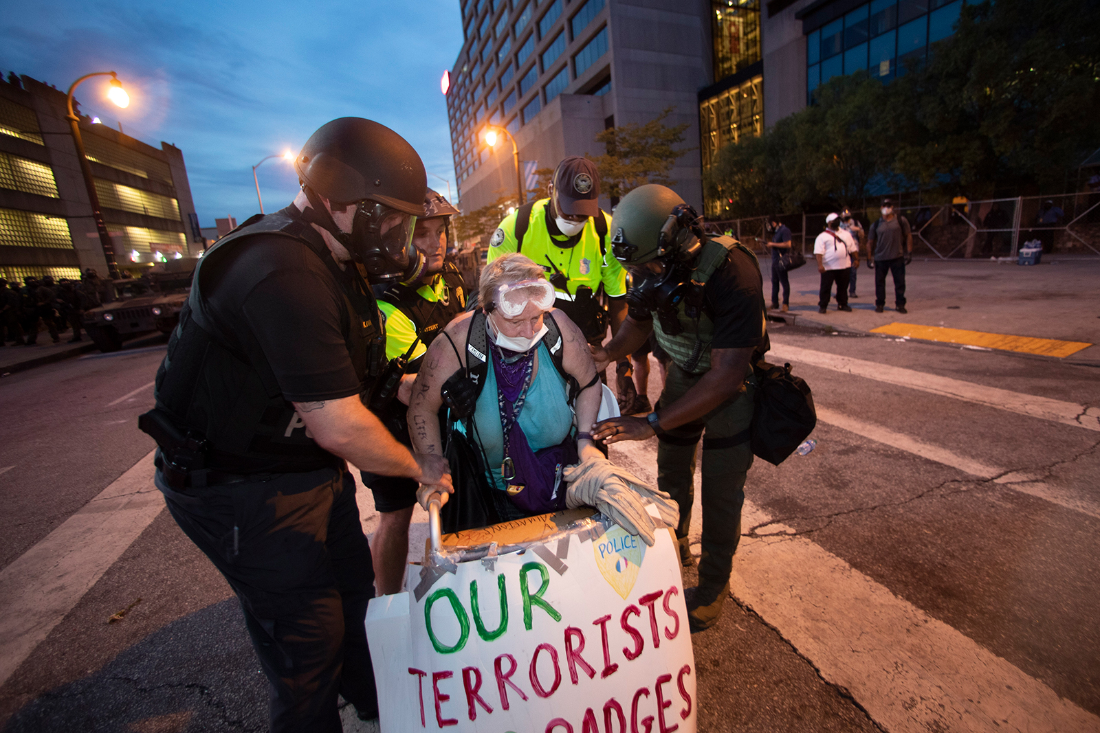 A woman is helped to her feet by police officers after she agreed to stop blocking a street during a protest, on June 3, in Atlanta.