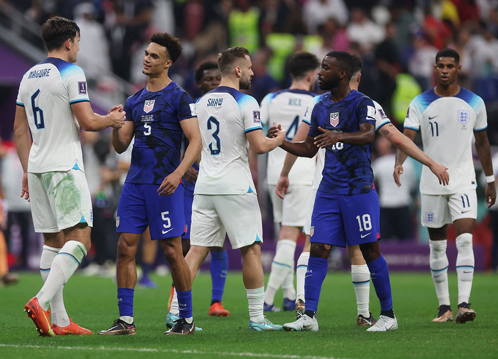 Members of the US and England teams shake hands after the match. 