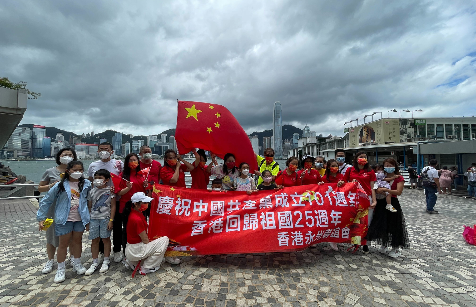 A group of about 30 people gathered to hold a Chinese national flag and a patriotic banner with the message "Celebrating the 101st year of the establishment of the Chinese Communist Party and the 25th handover anniversary of Hong Kong to the Chinese motherland, from the Hong Kong Hunan Fraternity Association," on July 1.
