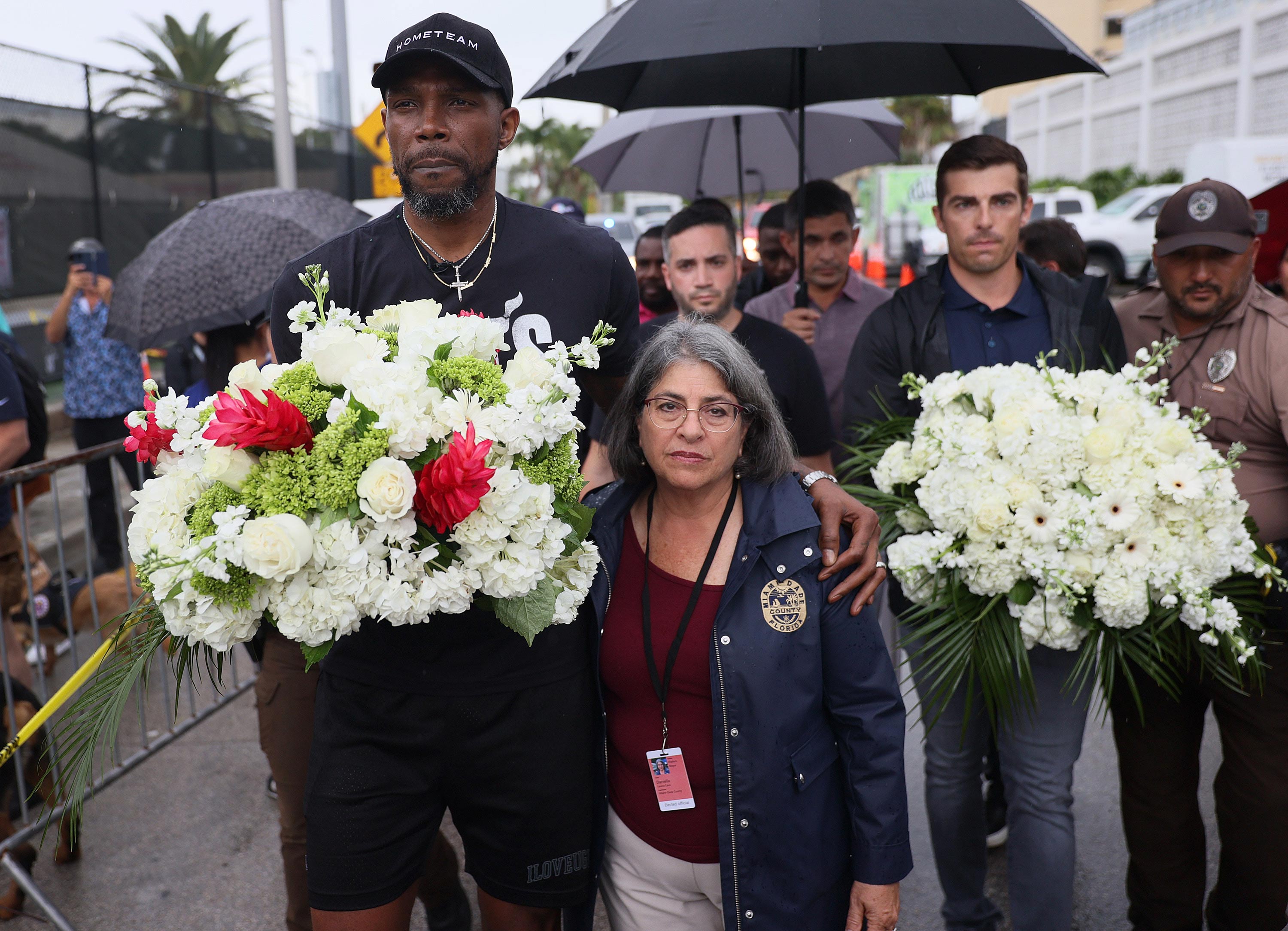 Udonis Haslem, from the Miami Heat basketball team, and Miami-Dade County Mayor Daniella Levine Cava arrive to pay their respects at a memorial to those missing from the partially collapsed Champlain Towers South condo building on June 30 Surfside, Florida. 