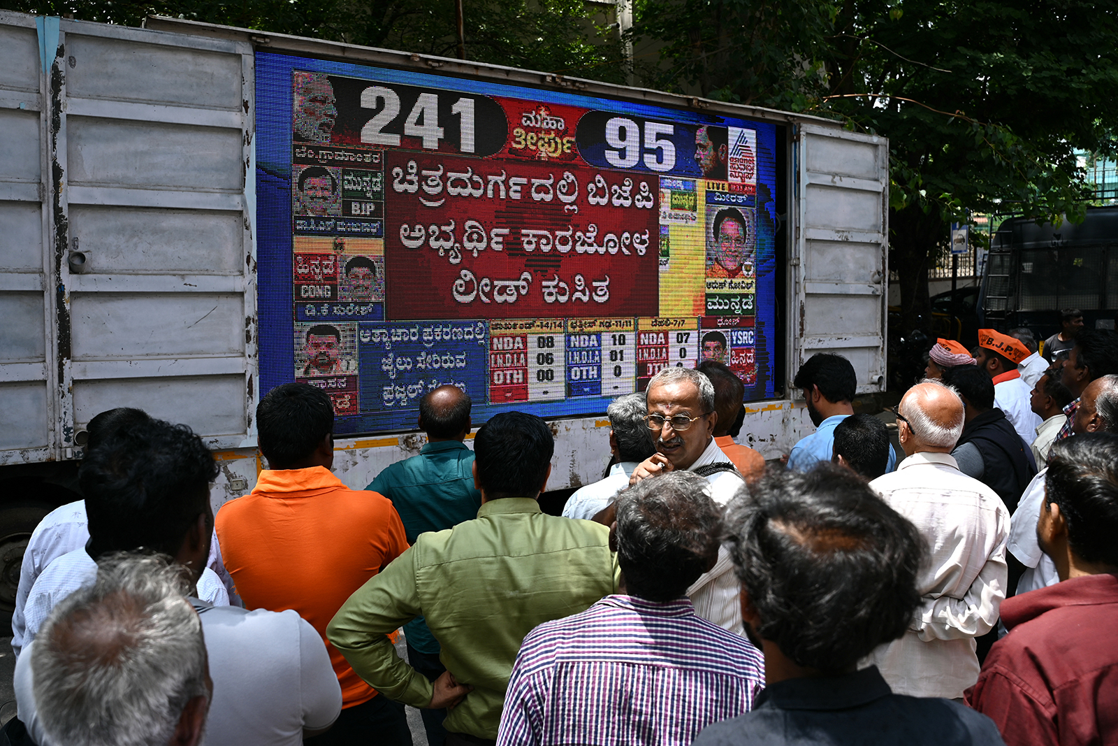 People watch latest vote counting results live on a large screen for India's general election at the Bharatiya Janata Party (BJP) office in Bengaluru, on June 4.