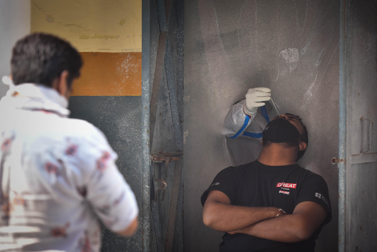 A health worker in PPE coveralls collects a swab sample from a man for coronavirus testing, at Khajuri Khas, on October 28, in New Delhi, India. 