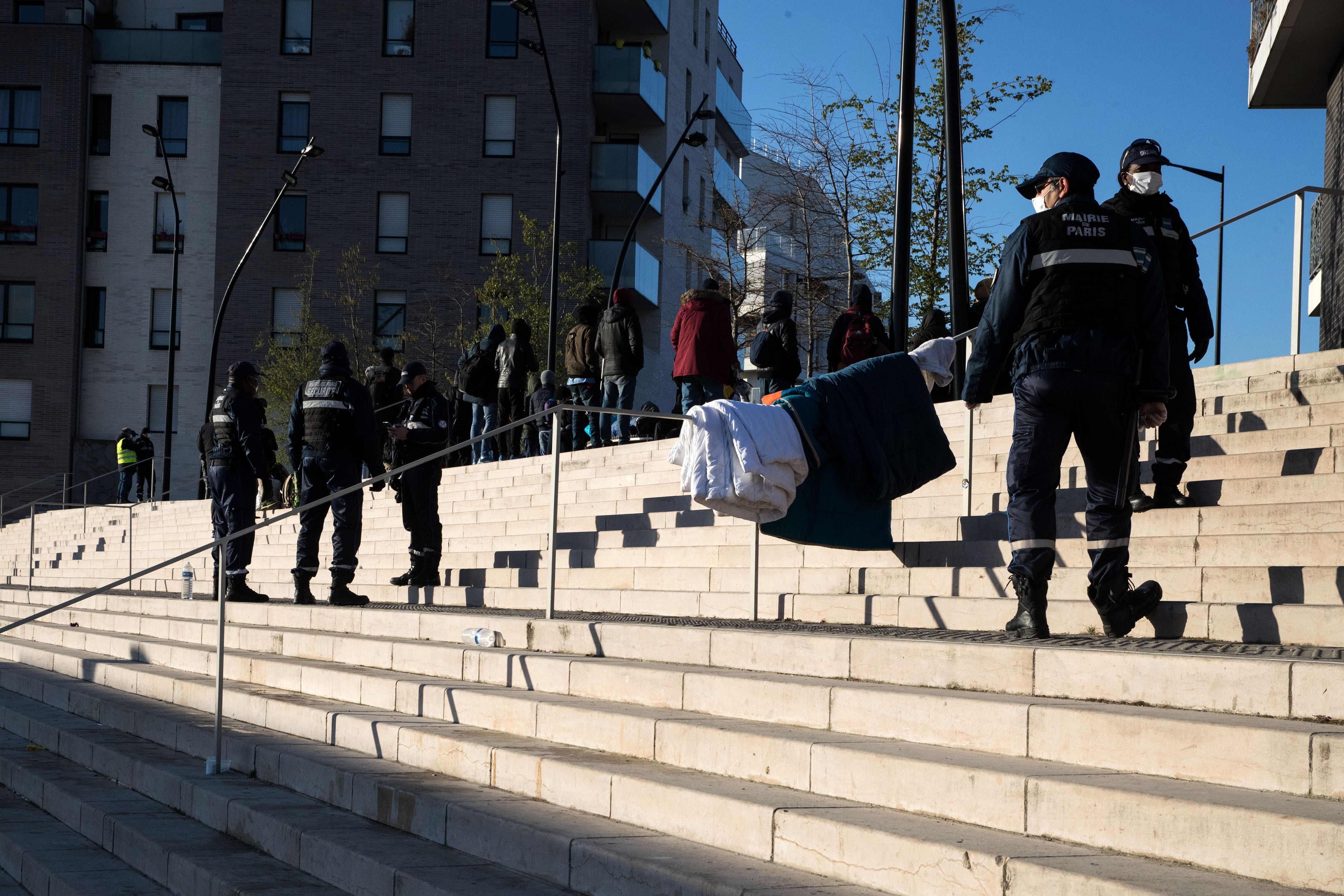 Police officers are seen following the evacuation of a camp for migrants in Aubervilliers, France, on March 24.