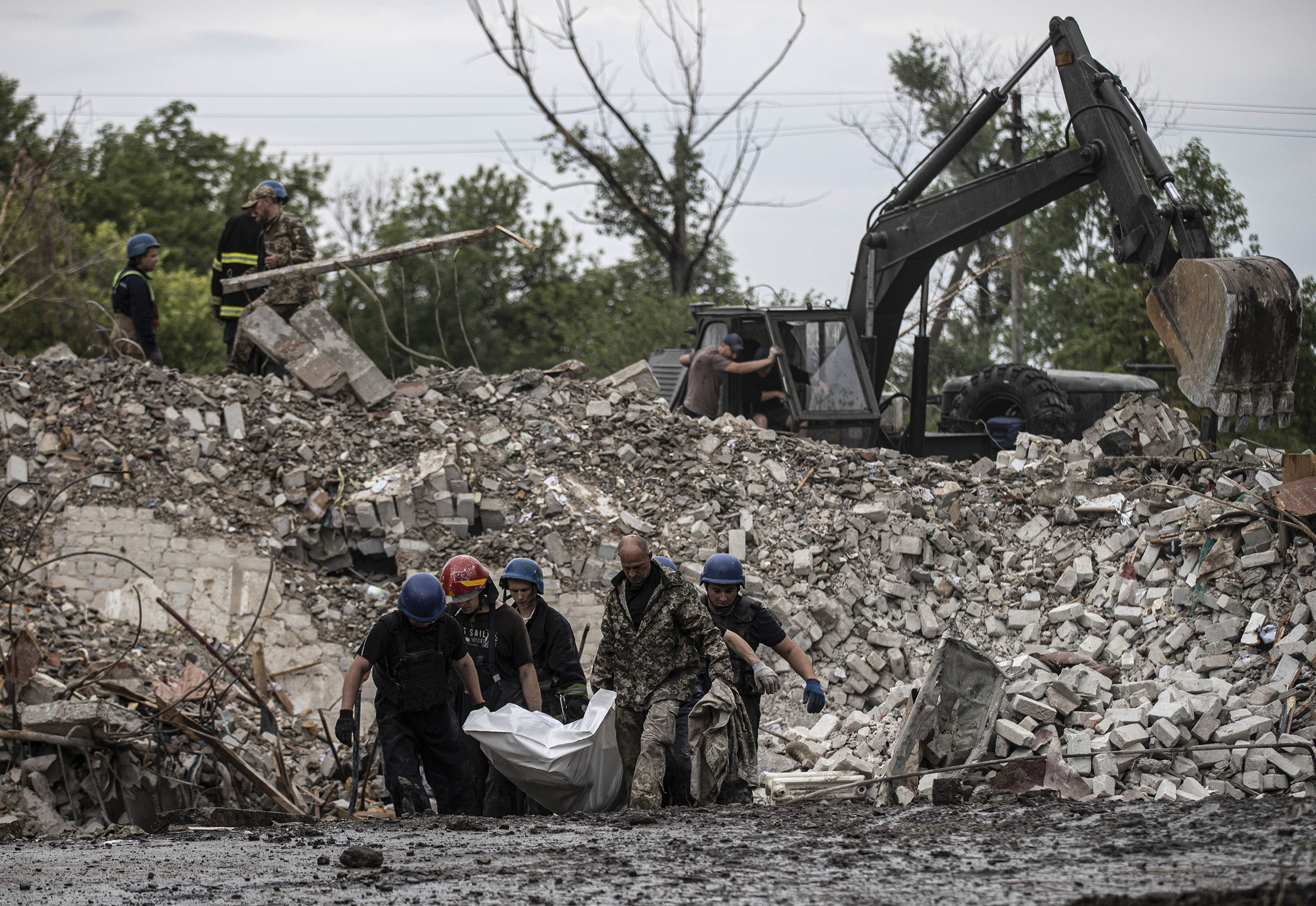 Firefighters remove a body as search and rescue operations continue after Russian airstrikes hit residential areas in Chasiv Yar, Donetsk, Ukraine, on July 11. 