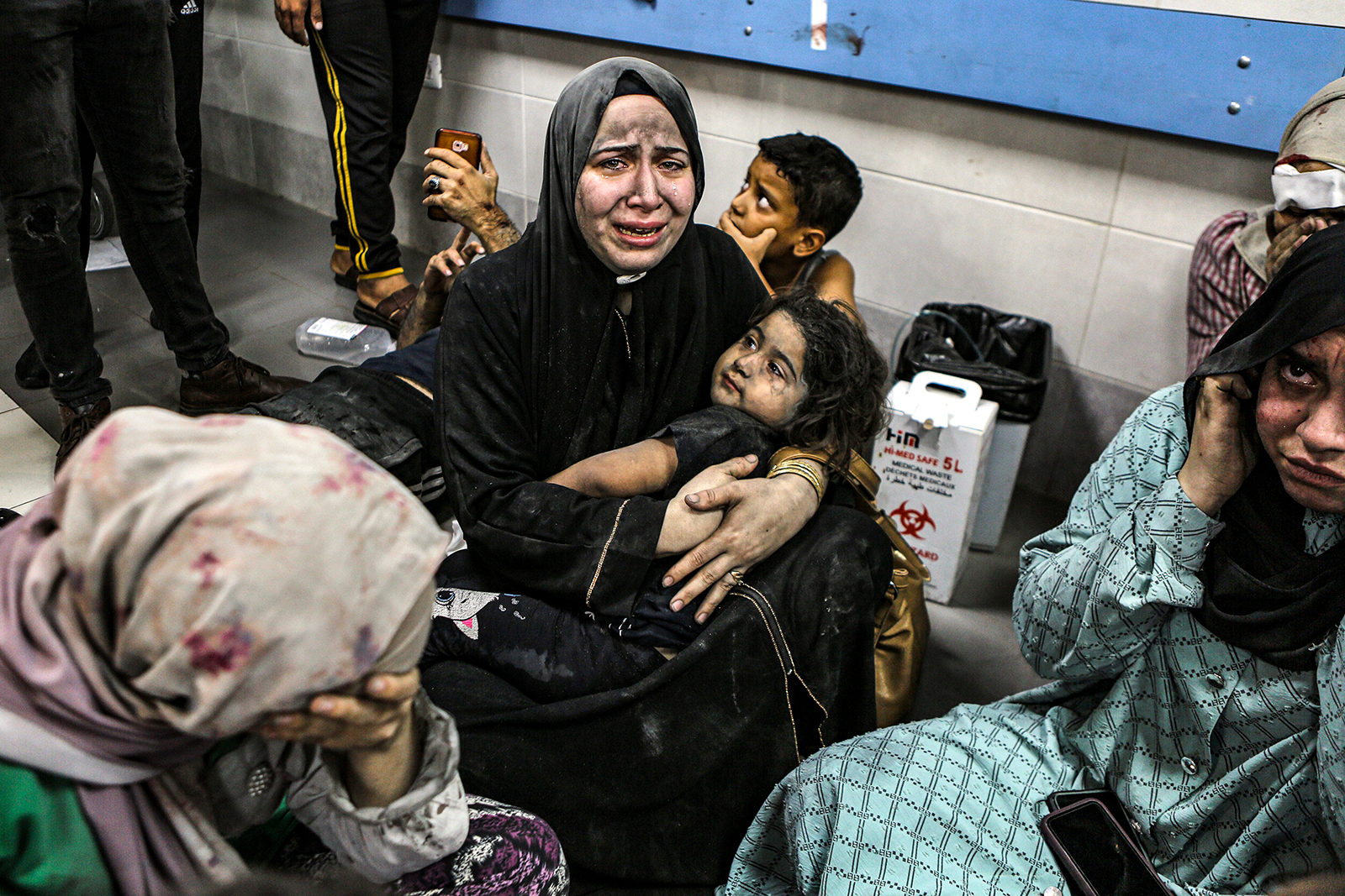 Wounded Palestinians sit on the floor at the Al-Shifa Hospital after being transported from the Al-Ahli Baptist Hospital following a blast there on October 17. 