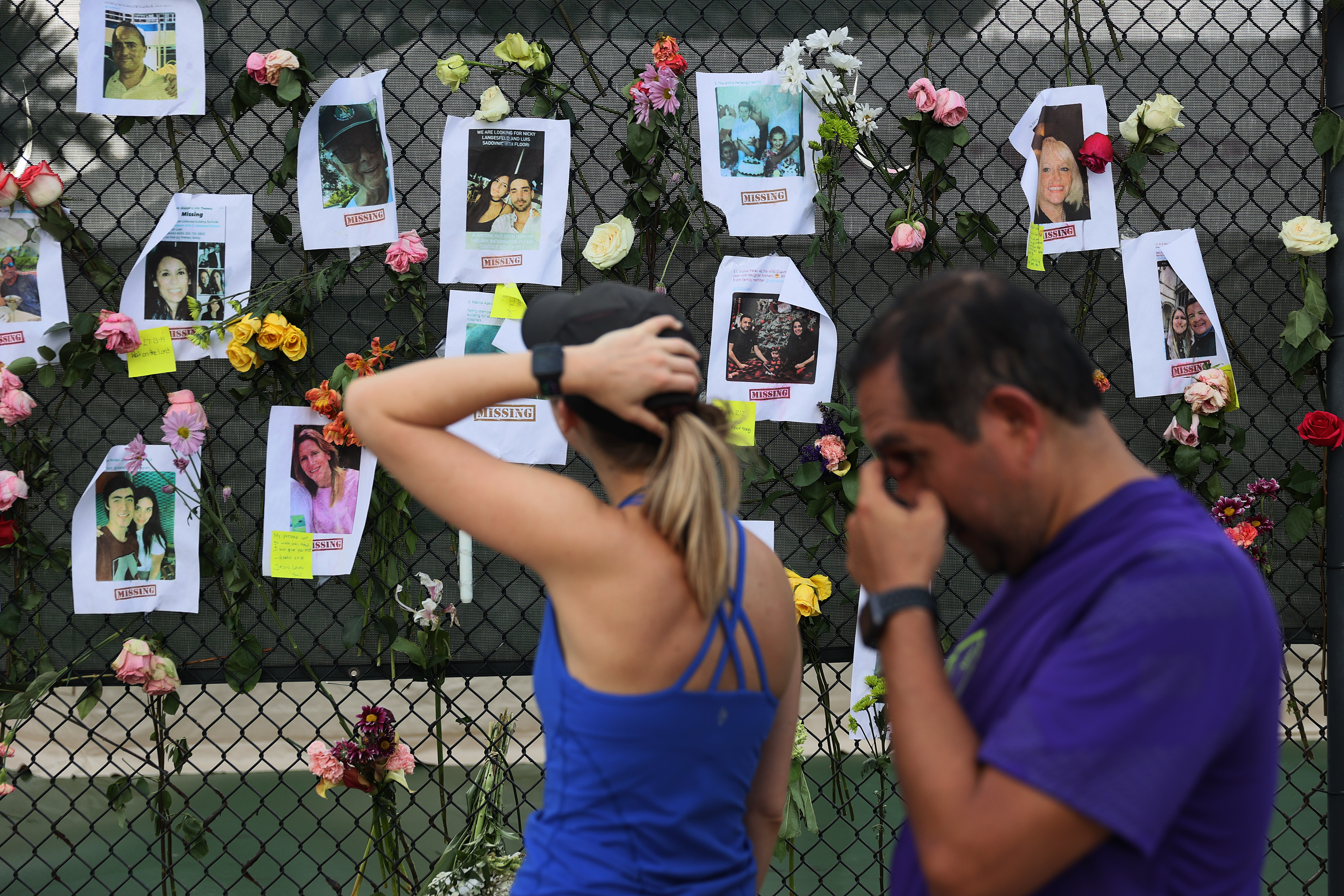 People look at the makeshift memorial of some of the missing from the partially collapsed 12-story Champlain Towers building on Saturday, June 26, 2021 in Surfside, Florida. 