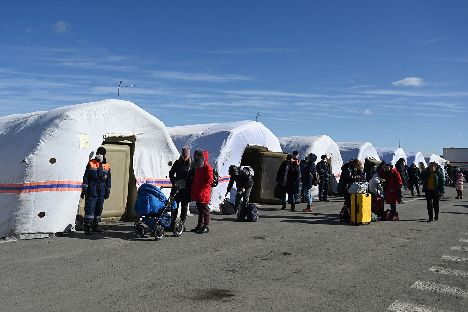 People gather at a tent camp at the Matveyev Kurgan border checkpoint after evacuating from Donetsk on February 19. 