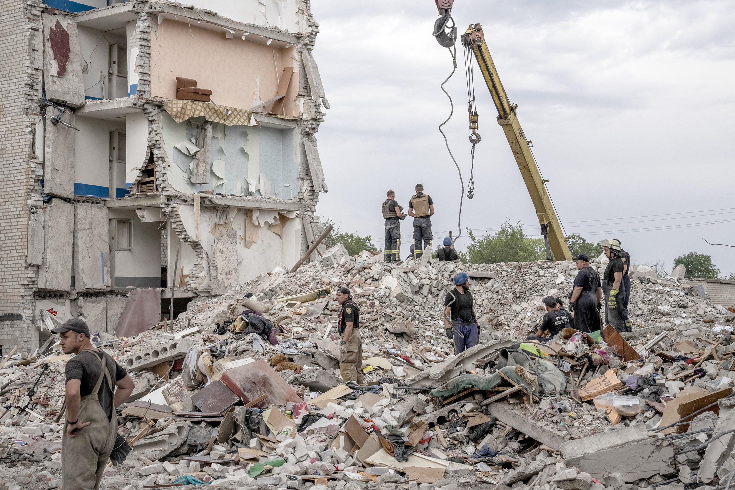 Rescue workers stand on the rubble in the aftermath of a Russian rocket attack that hit an apartment residential block, in Chasiv Yar, Donetsk region, eastern Ukraine, on July 10.