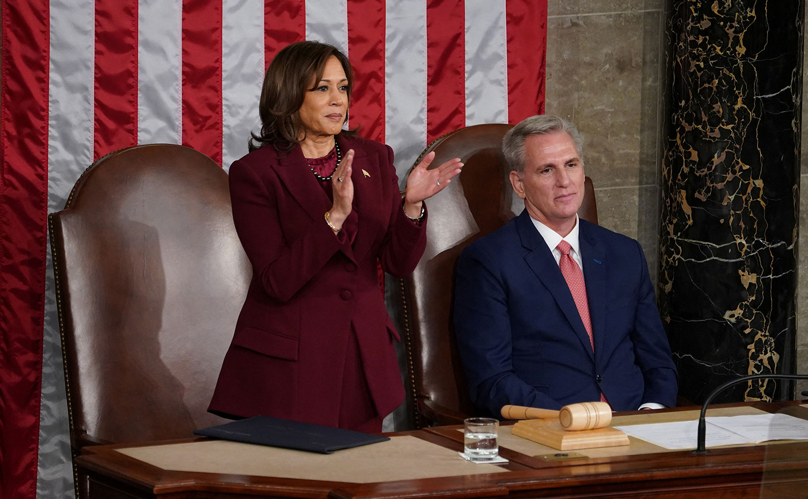 Vice President Kamala Harris stands and applauds as House Speaker Kevin McCarthy remains seated.