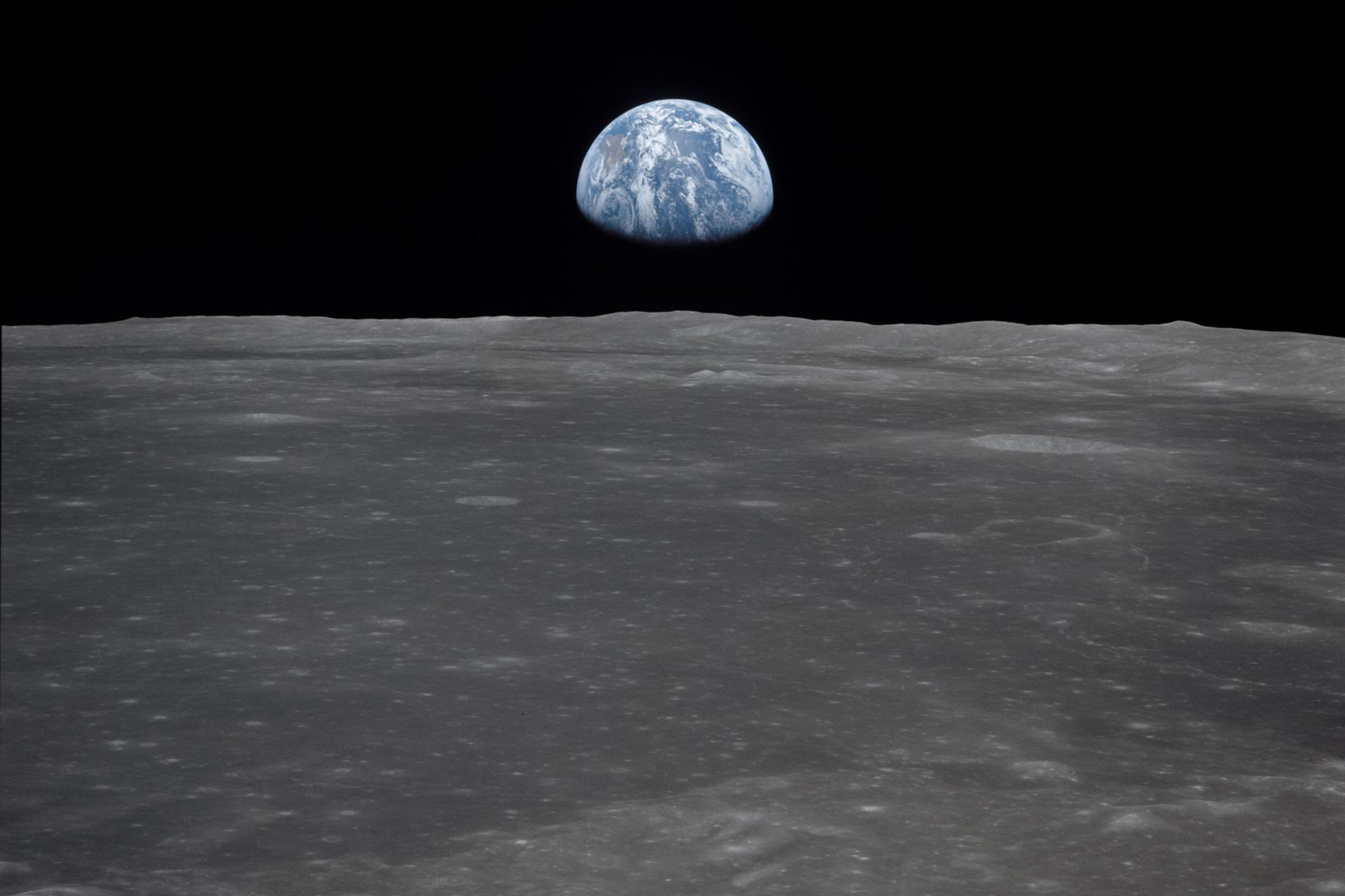 This view from the Apollo 11 spacecraft shows the Earth rising above the moon's horizon, in July 1969.