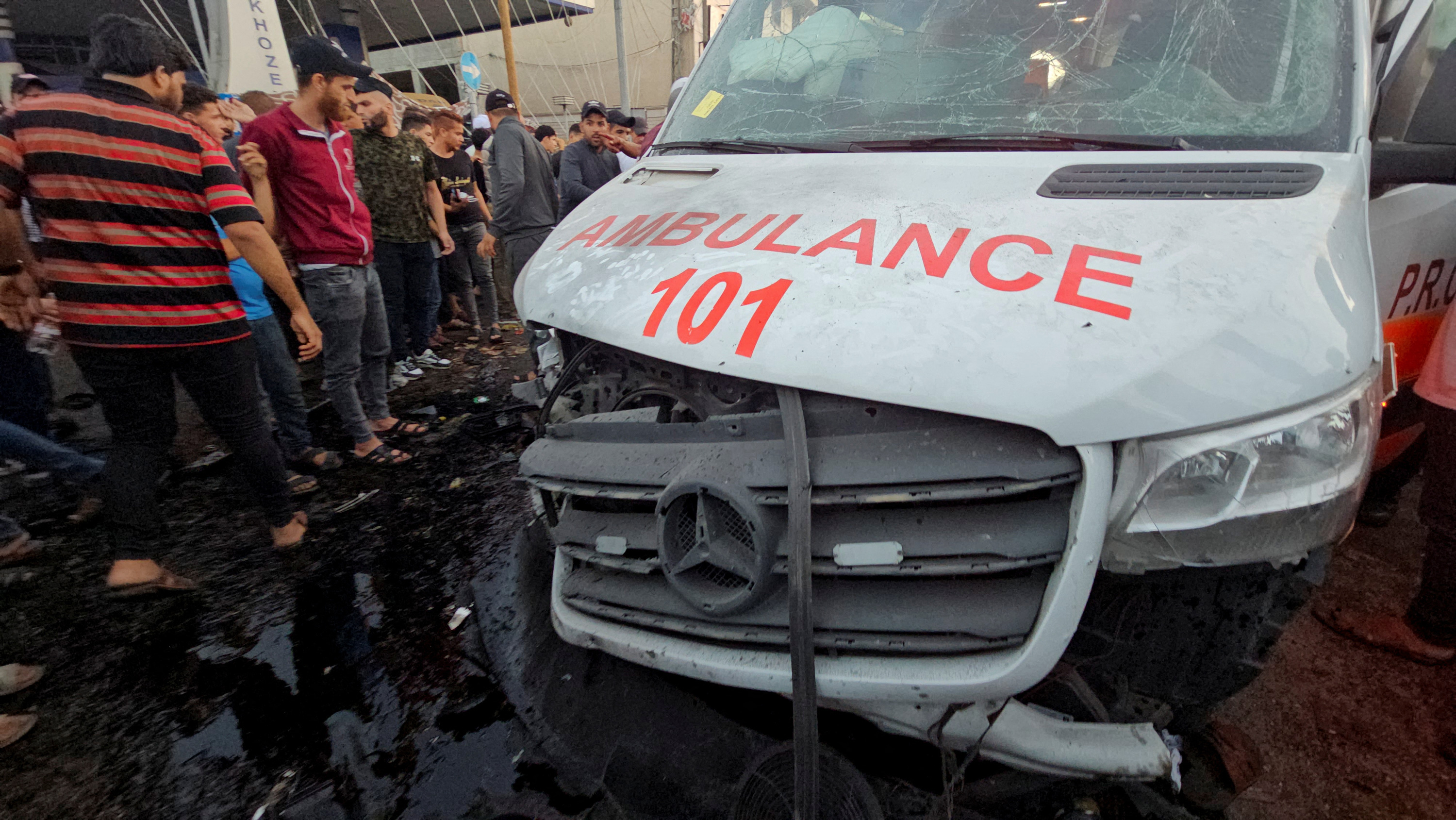 Palestinians check the damage on an ambulance after a convoy of ambulances was hit near the entrance of Al-Shifa hospital in Gaza City.