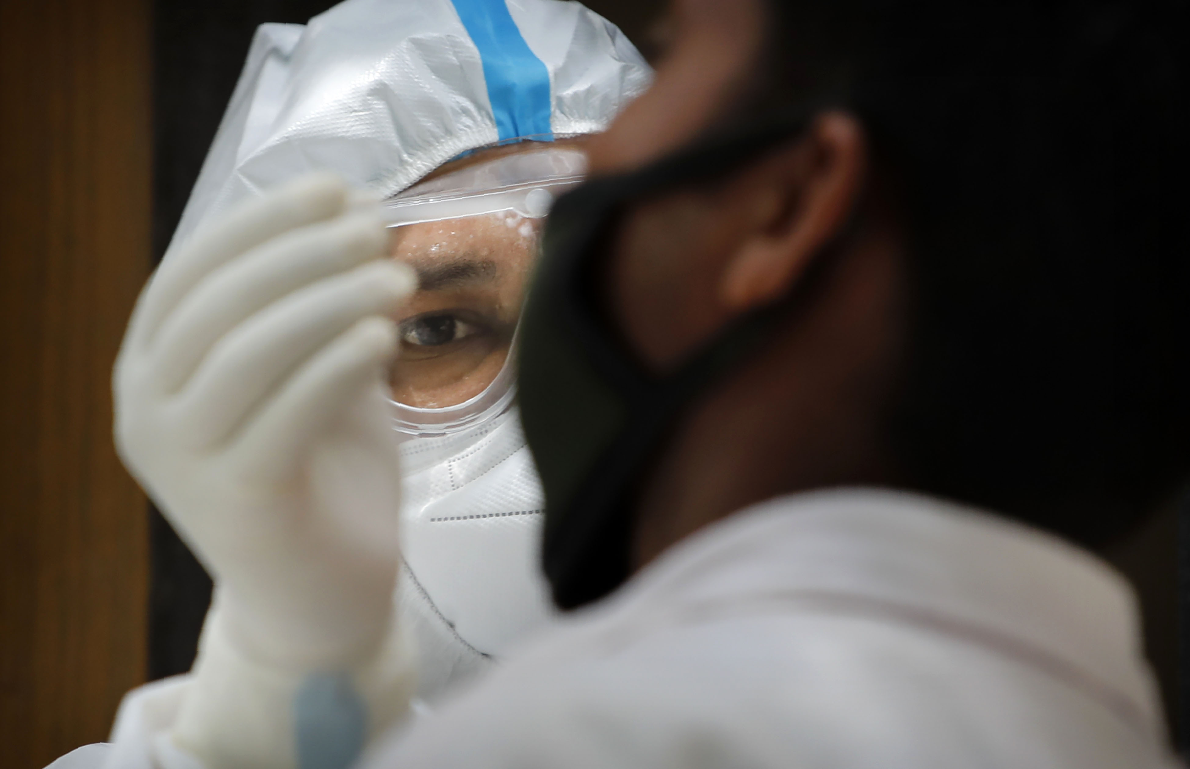 A health care worker in New Delhi, India, takes a nasal swab for a Covid-19 test on August 22.