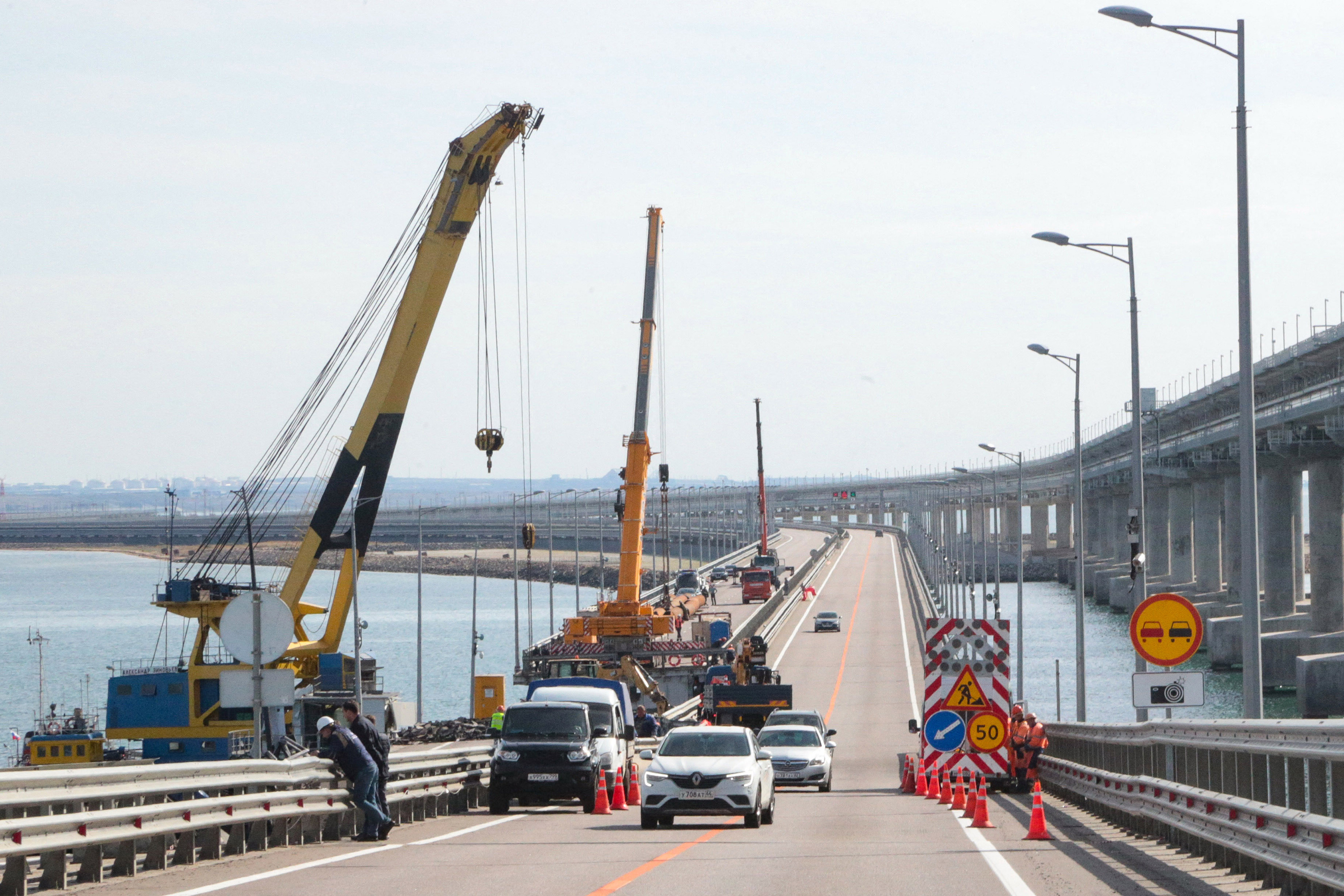 Workers restore the damaged parts of Kerch Bridge that links Crimea to Russia on October 13.