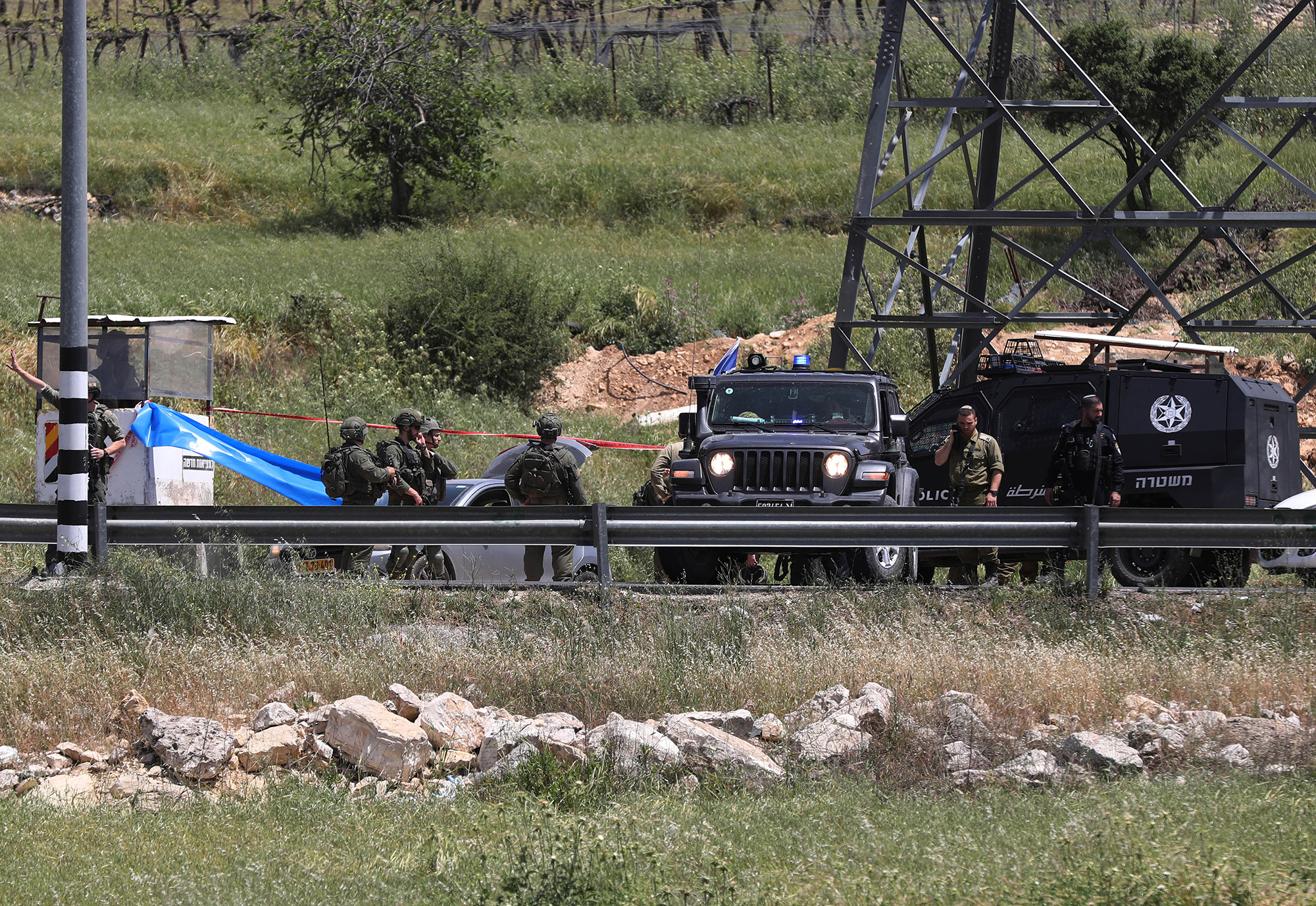 Israeli security forces block the road and investigate the scene after Israeli soldiers shot a Palestinian woman  near Hebron, West Bank, on April 24.