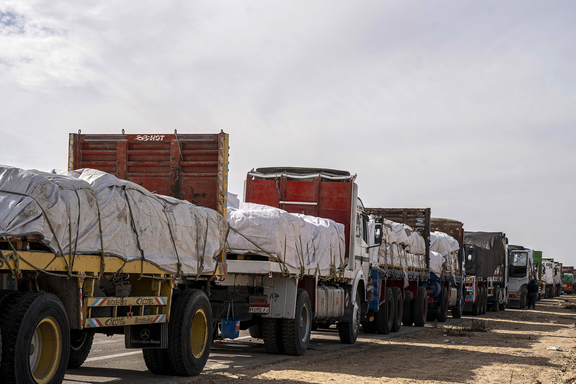 Trucks carrying aid wait to enter Gaza via the Rafah crossing on November 22, in Arish, Egypt.