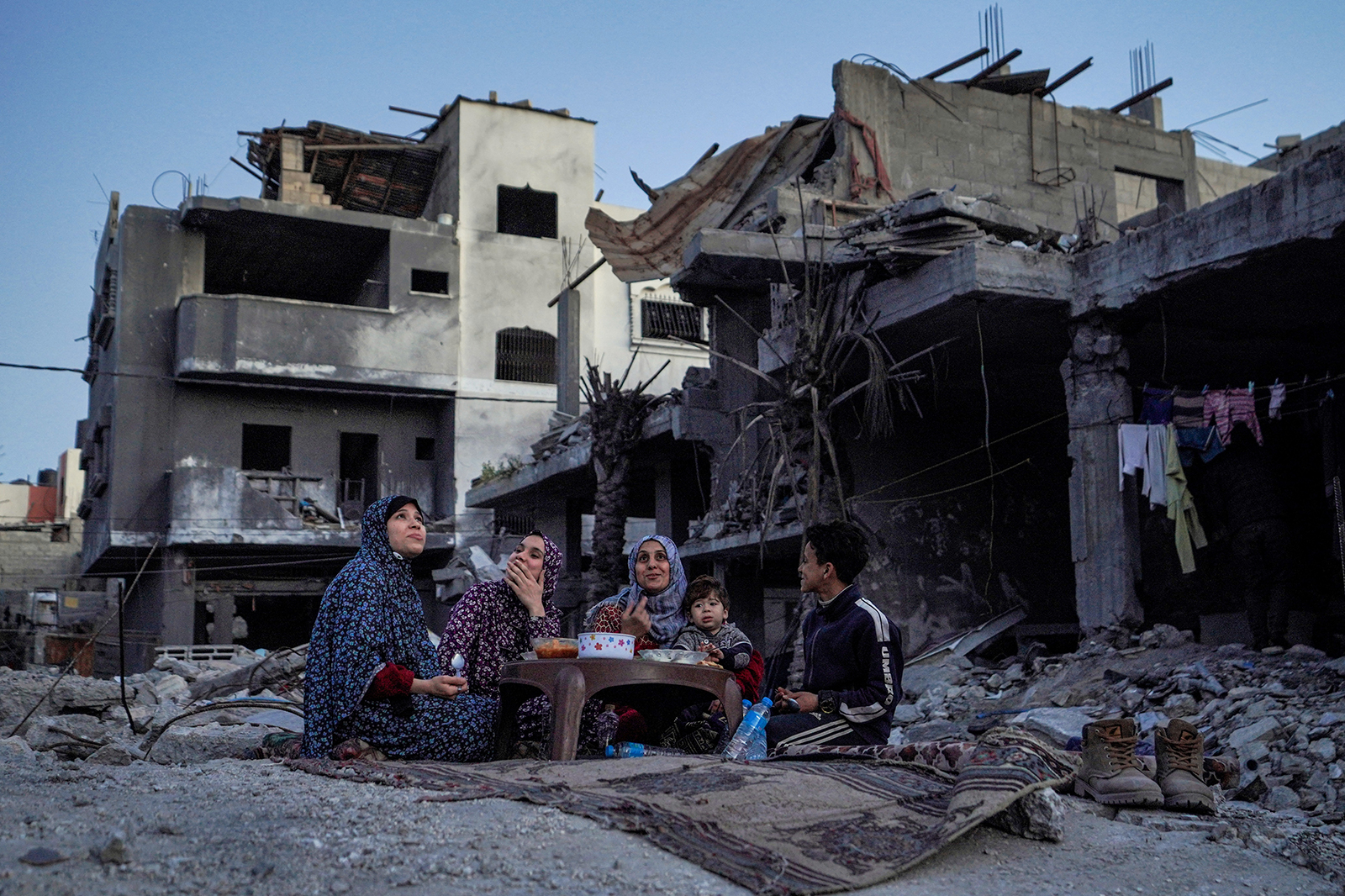 A Palestinian family eats an iftar meal, the breaking of fast, in the ruins of their house in Deir el-Balah, in central Gaza, on March 11.