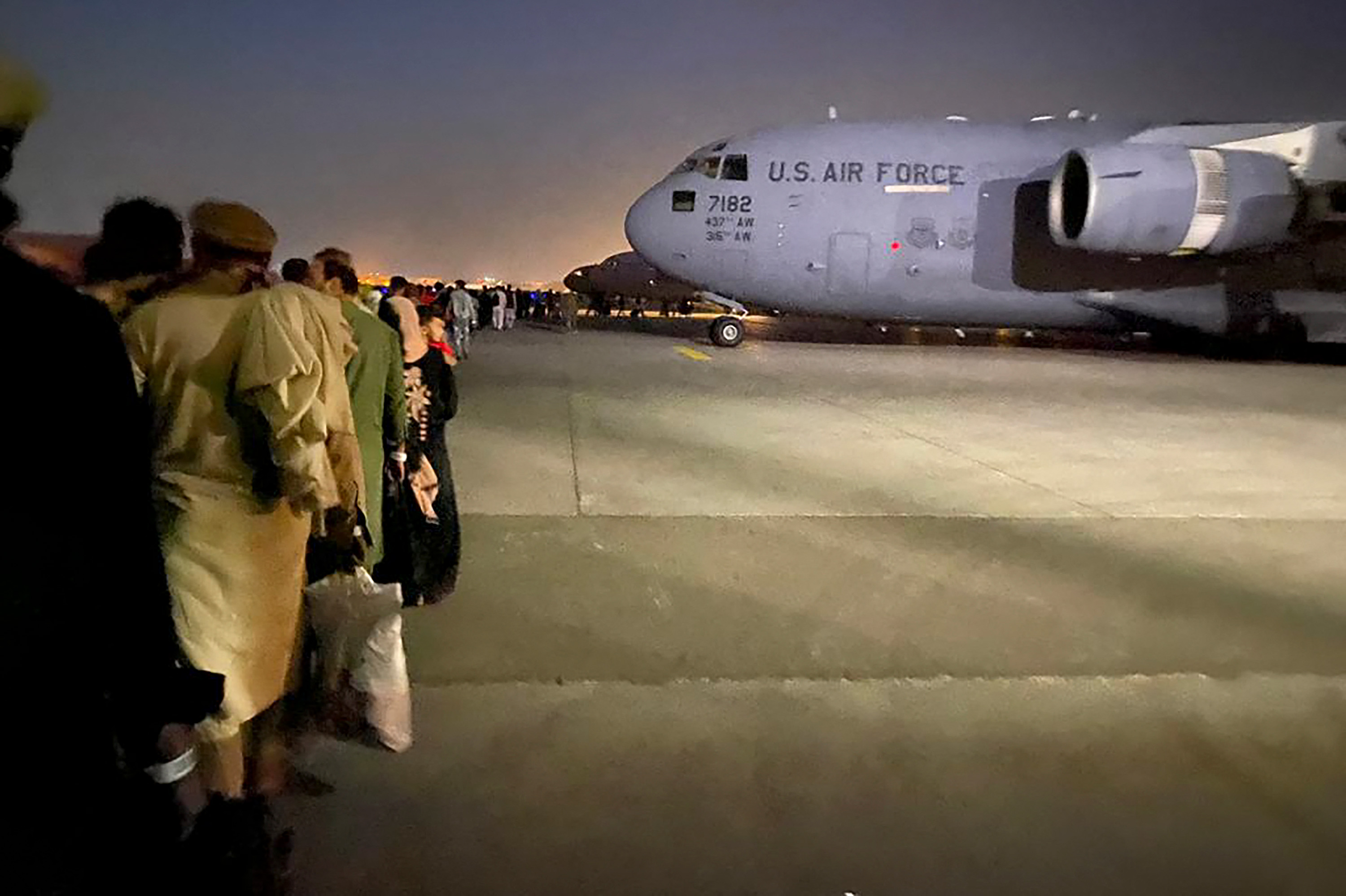 People queue up to board a US military aircraft to leave Afghanistan at the military airport in Kabul on August 19.