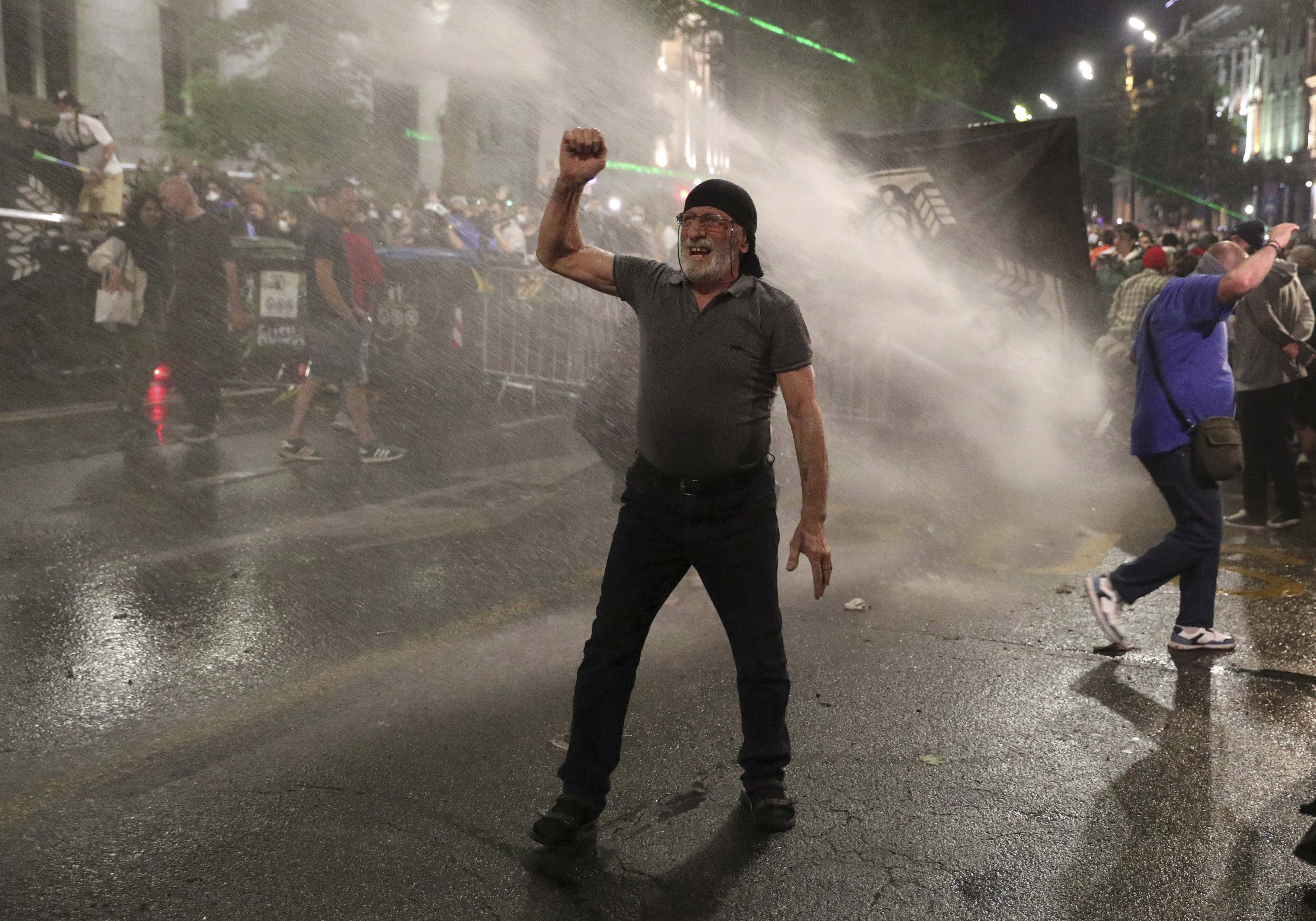 Law enforcement officers use water cannons to disperse protesters in Tbilisi on May 1. 
